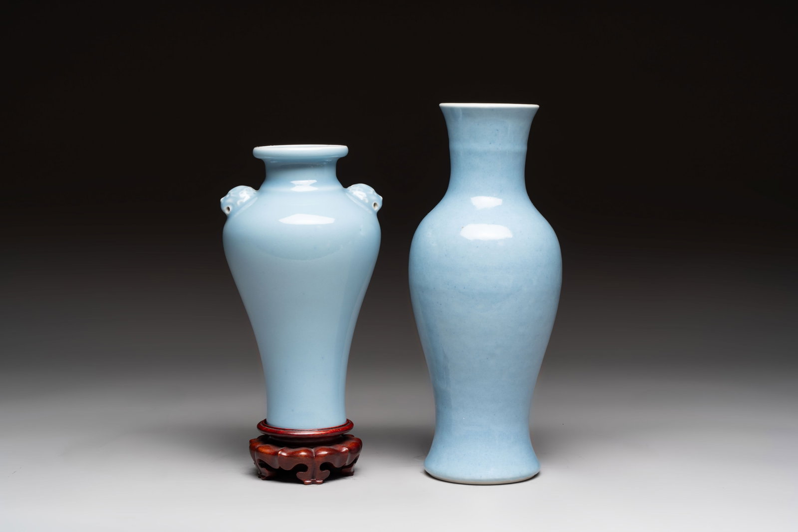 Two Chinese claire-de-lune vases, one with a wooden stand, Kangxi and Yongzheng mark, 19/20th C.: Two Chinese claire-de-lune vases, one with a wooden stand, Kangxi and Yongzheng mark, 19/20th C. H.: 25,5 cm (the tallest) H.: 23 cm (the smallest, incl. stand)