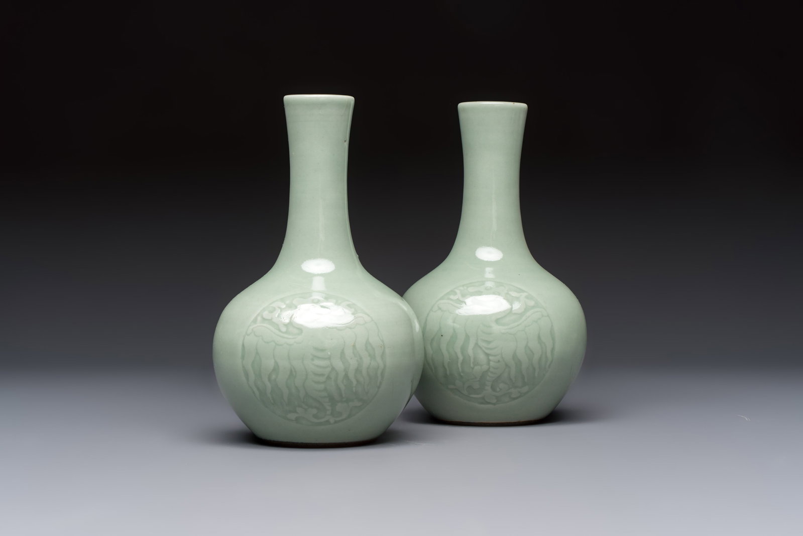 A pair of Chinese celadon-glazed bottle vases with incised phoenix design, Yongzheng mark, 19th C.: A pair of Chinese celadon-glazed bottle vases with incised phoenix design, Yongzheng mark, 19th C. H.: 17 cm