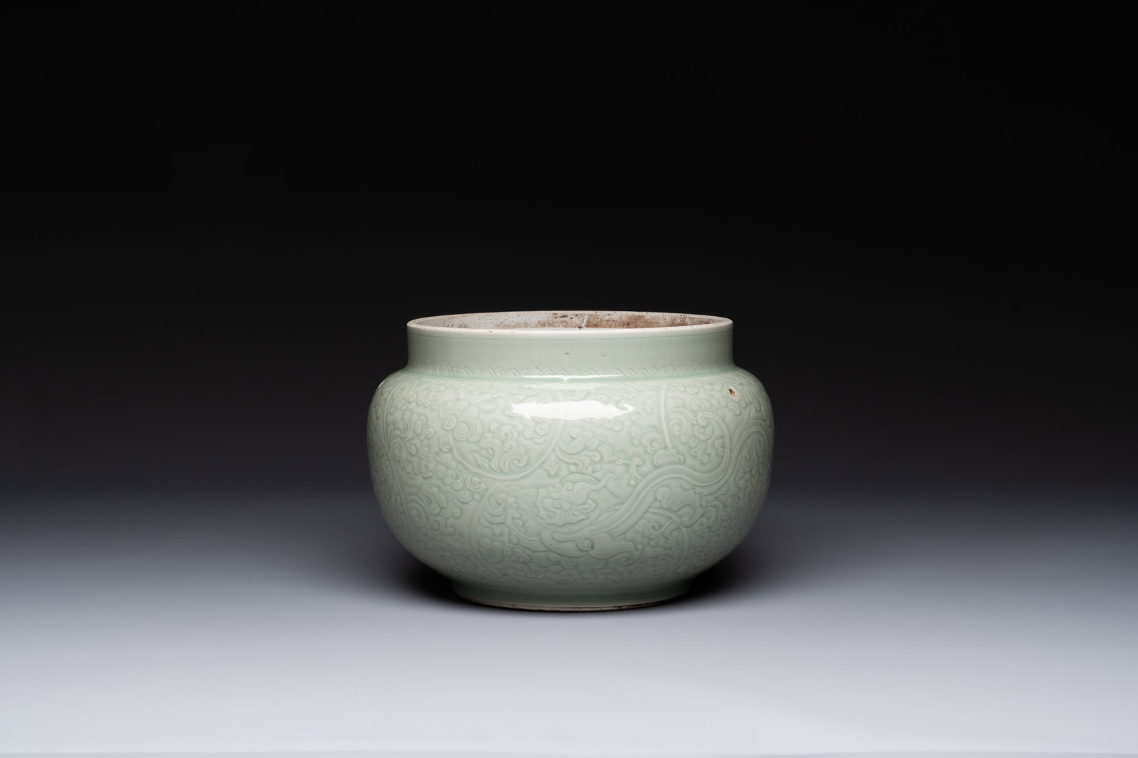A Chinese celadon-glazed bowl with incised chilong among floral scrolls, Kangxi (1 of 6)