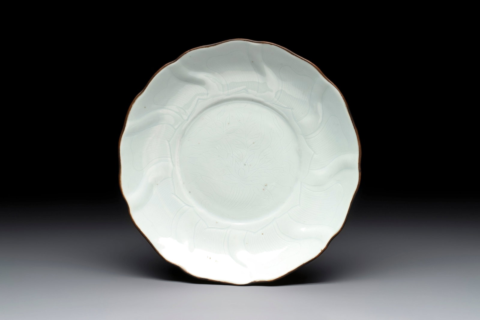 A Chinese moulded white-glazed plate with anhua floral design and a copper-mounted rim, Xuande mark, (1 of 4)