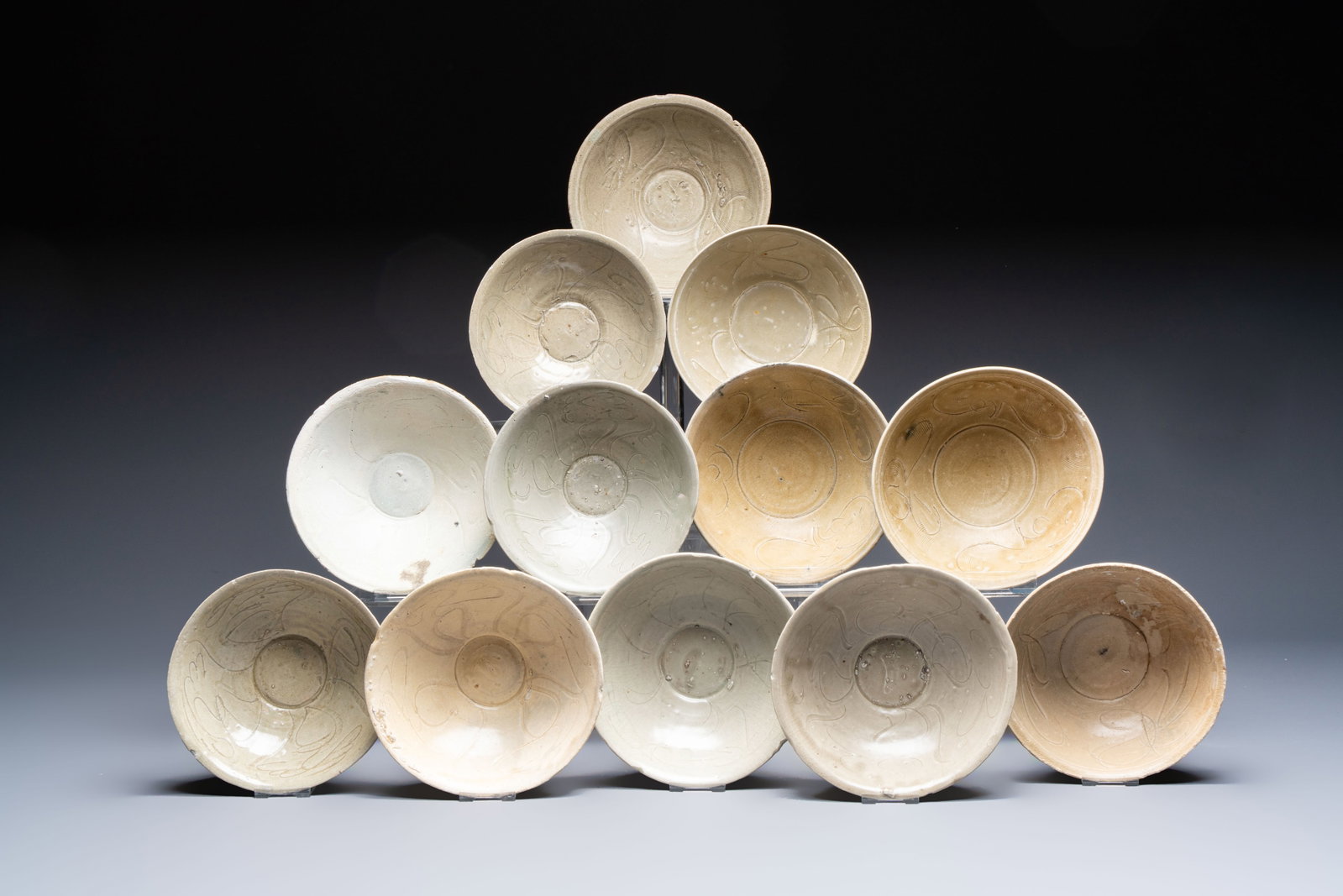 A group of 12 Chinese celadon-glazed bowls with incised floral design from the Jepara shipwreck,: A group of 12 Chinese celadon-glazed bowls with incised floral design from the Jepara shipwreck, Fujian kilns, Song Dia.: 18 cm - H.: 7,6 cm (the largest bowl) Provenance: - Collection of Drs. M.B.P.M