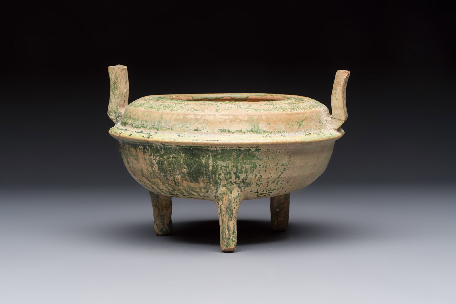A Chinese green-glazed pottery ritual tripod food vessel with handles, 'Ding', Han (1 of 6)