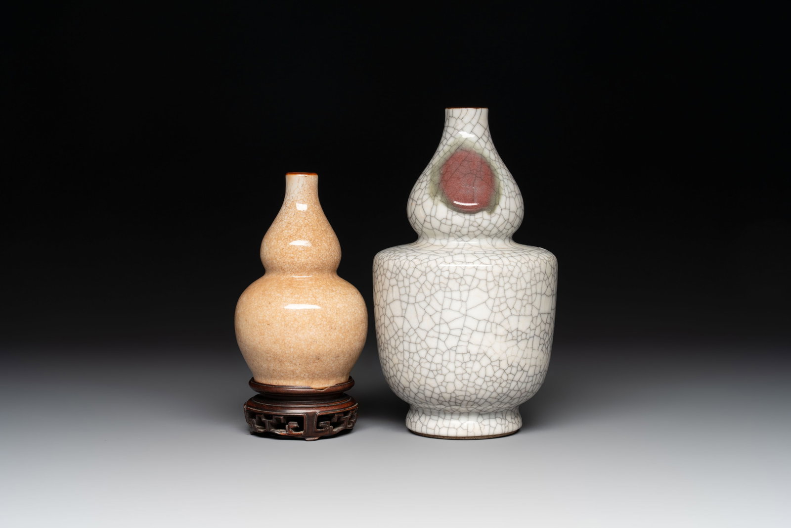 Two Chinese ge-type double-gourd vases, one with a wooden stand, 19/20th C.: Two Chinese ge-type double-gourd vases, one with a wooden stand, 19/20th C. H.: 19,5 cm (the tallest) H.: 12,3 cm (the smallest, excl. stand)