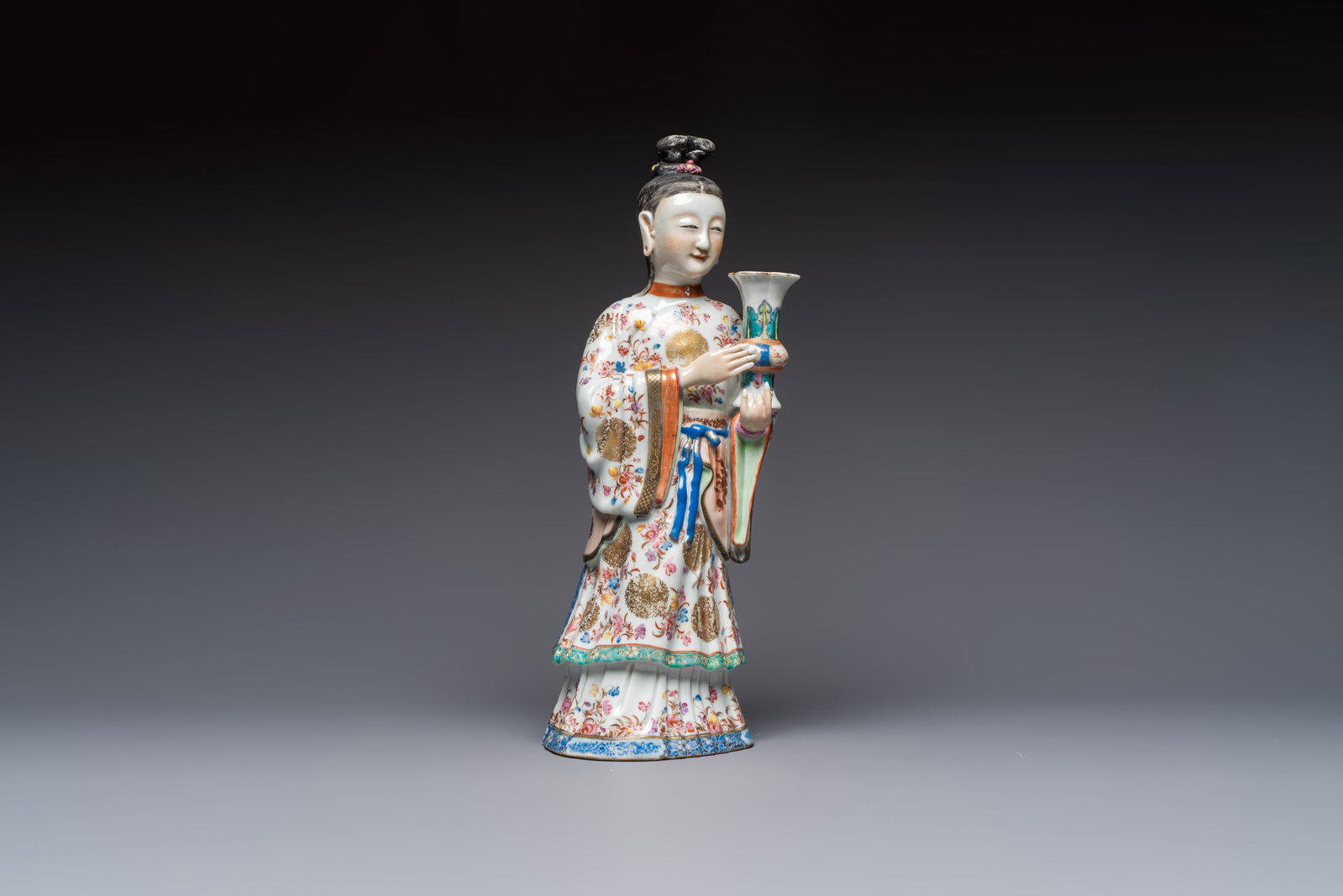 A Chinese famille rose candle holder in the shape of a court lady holding a 'Gu' vase, Qianlong: A Chinese famille rose candle holder in the shape of a court lady holding a 'Gu' vase, Qianlong H.: 41,5 cm Ref.: - Christie's London, 22 April 1991, lot 31 for an identical pair. (sold GBP 18.700,00)
