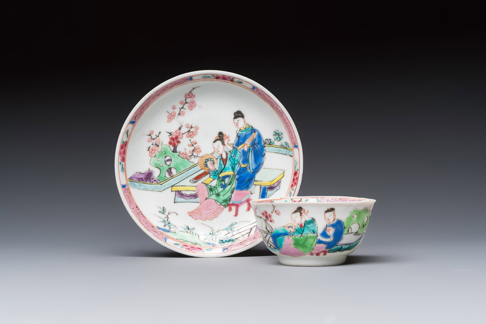A fine Chinese famille rose cup and saucer with a couple on a terrace, Yongzheng/Qianlong: A fine Chinese famille rose cup and saucer with a couple on a terrace, Yongzheng/Qianlong Dia.: 11 cm (the saucer) Dia.: 7 cm - H.: 3,5 cm (the cup)
