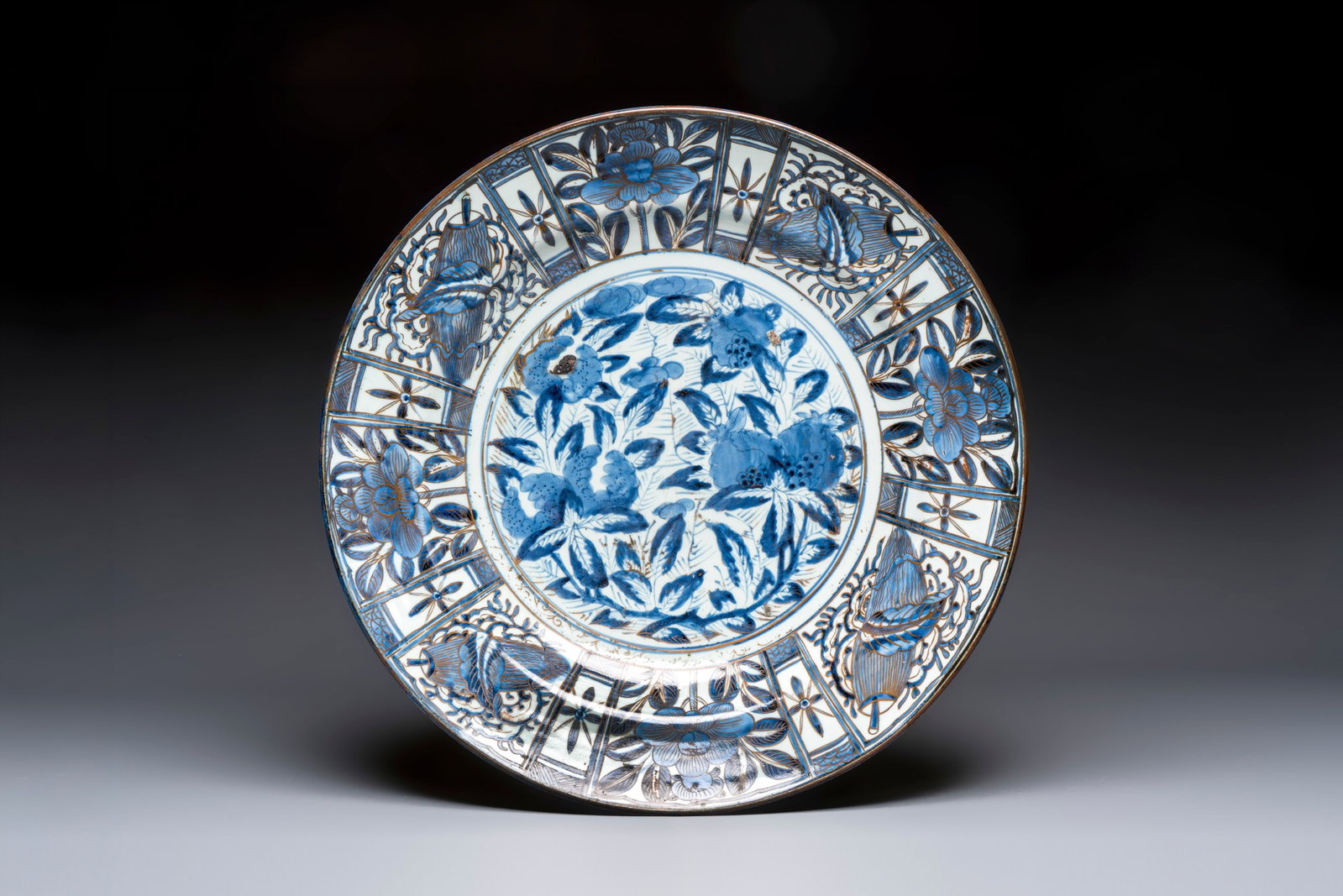 A massive Japanese Arita blue and white gilt-decorated dish with floral design, Edo, 17th C. (1 of 2)