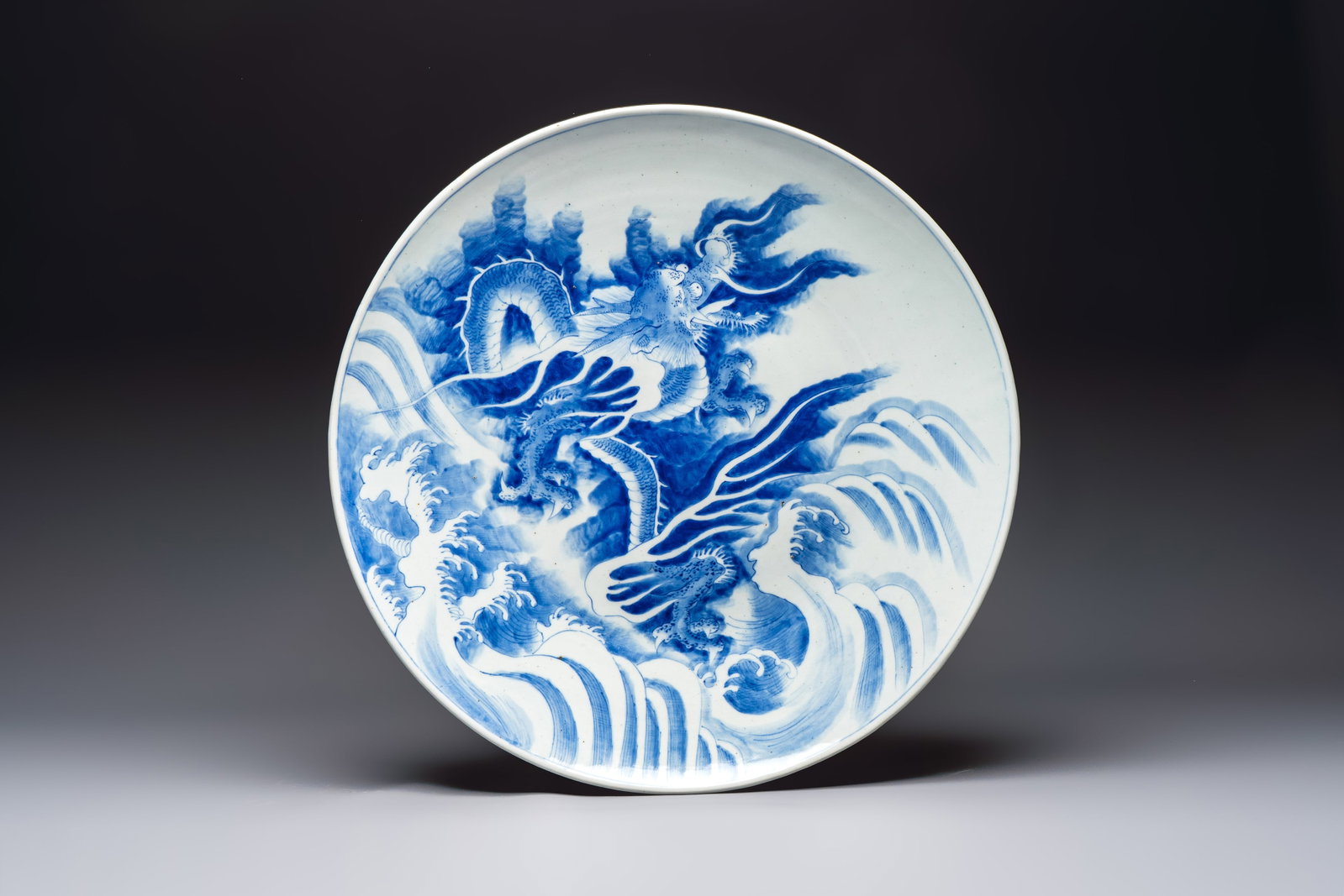 A massive Japanese blue and white 'Dragon among Sea Waves' dish, probably Arita, Meiji, 19th C. (1 of 2)