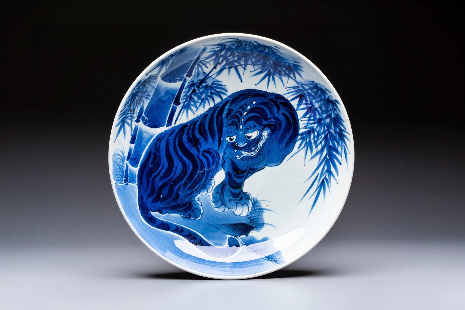 A large Japanese Arita blue and white 'Tiger' dish, Fuuki Chousun mark, late Edo to (1 of 2)