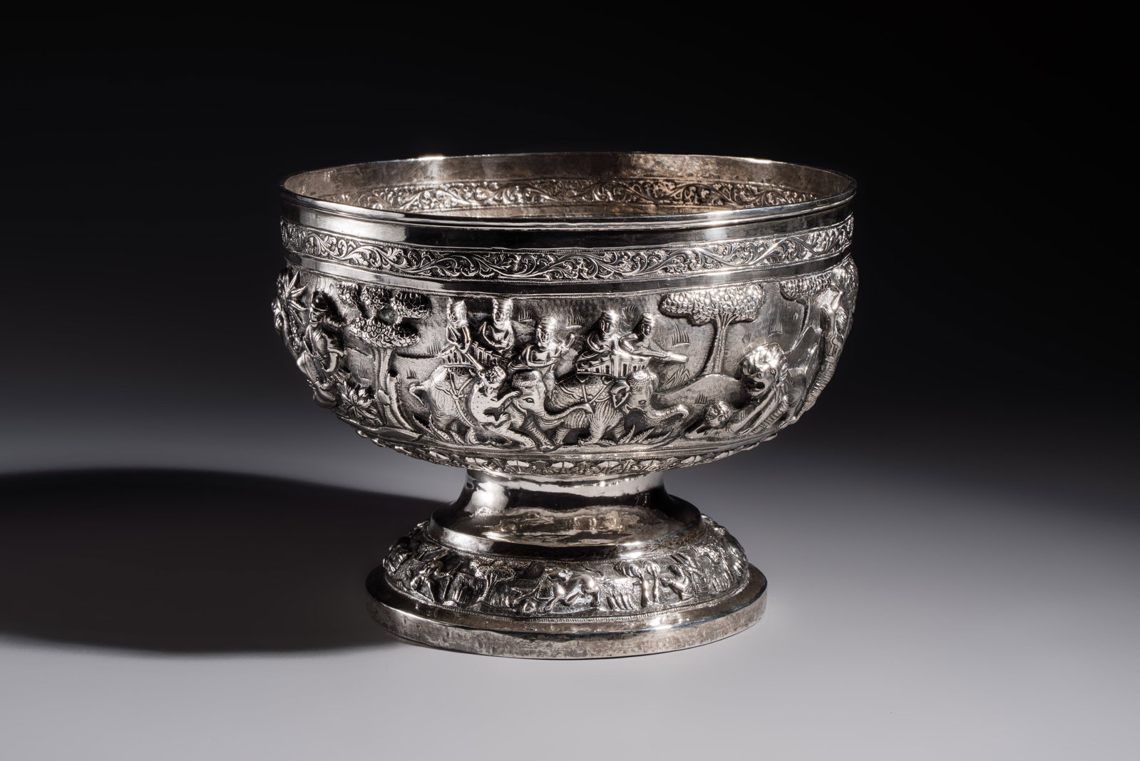 A large repoussé silver footed bowl depicting a hunting scene, India, late 19/early 20th C.: A large repoussé silver footed bowl depicting a hunting scene, India, late 19/early 20th C. Dia.: 26,6 cm - H.: 19,8 cm Weight: 1310 grams