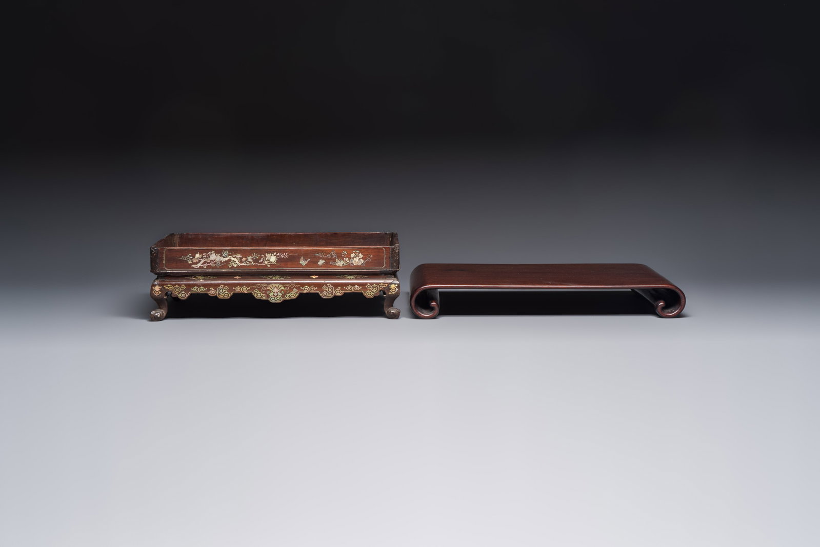 A Chinese or Vietnamese mother-of-pearl-inlaid wooden tray and a Chinese hongmu stand, 19/20th C.: A Chinese or Vietnamese mother-of-pearl-inlaid wooden tray and a Chinese hongmu stand, 19/20th C. Dim.: 31,7 x 19,1 x 9,5 cm (the tray) Dim.: 35,6 x 22,5 x 4,4 cm (the stand)