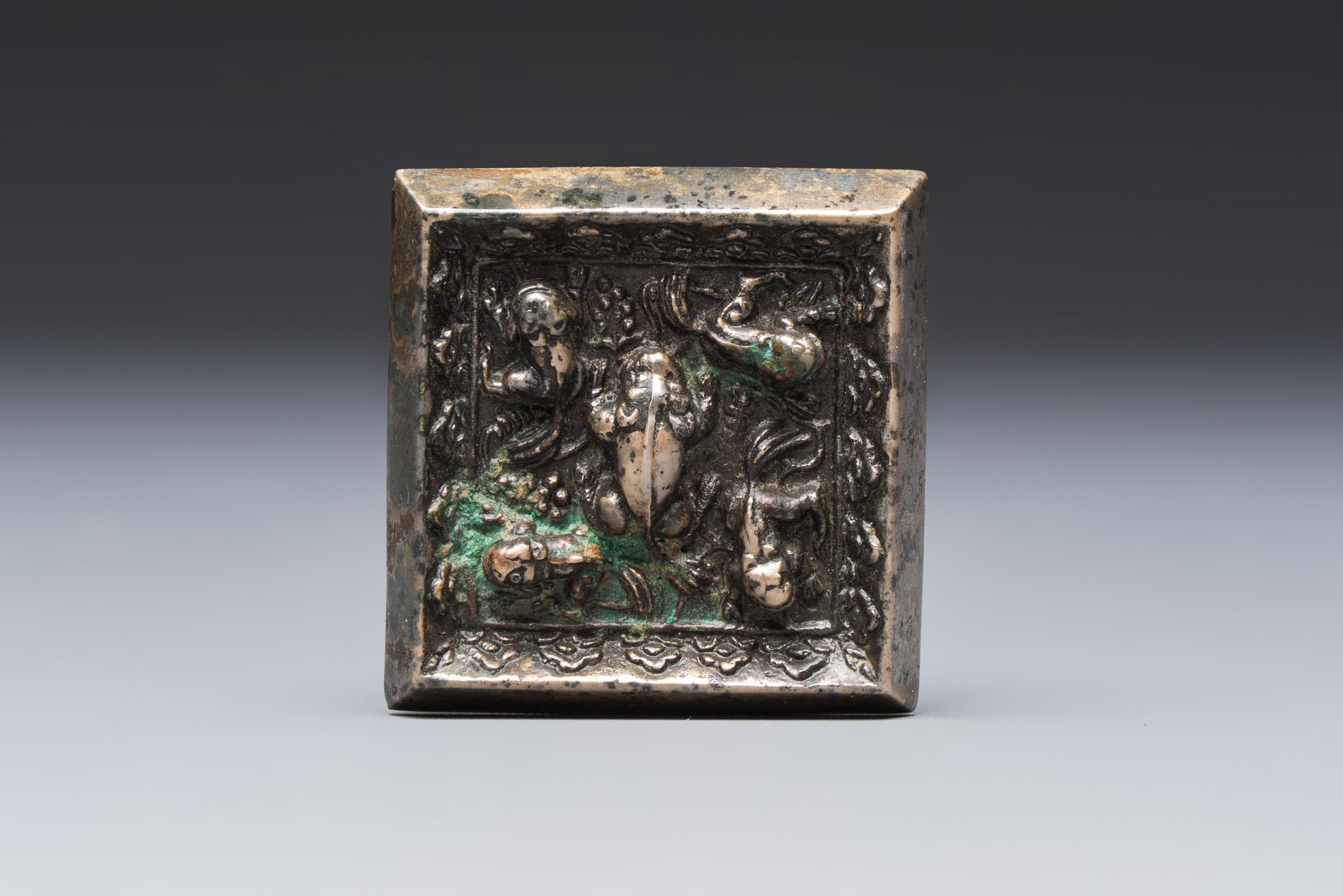 A small Chinese metal-alloy square mirror with relief design, Tang (1 of 2)
