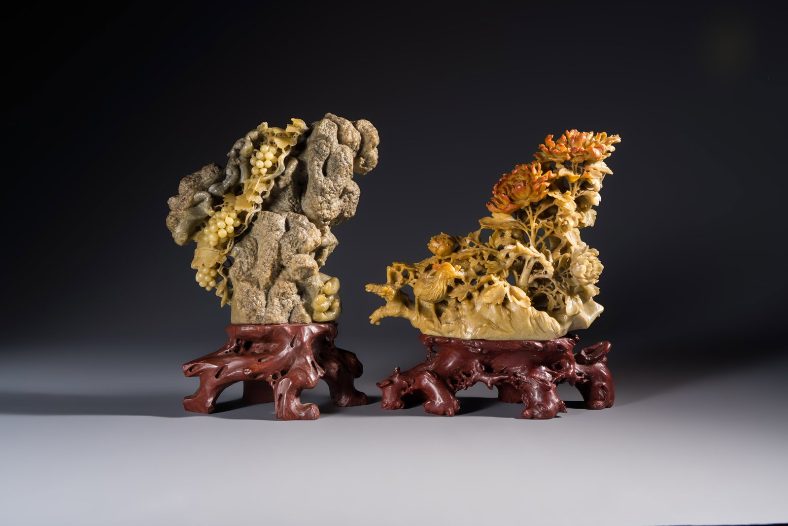 A fine Chinese carved soapstone 'Squirrels and Grapes' group and a 'Phoenixes among Peonies' group,: A fine Chinese carved soapstone 'Squirrels and Grapes' group and a 'Phoenixes among Peonies' group, 20th C. H.: 25,4 cm (the tallest) H.: 23,9 cm (the smallest) Weight: 5,4 kilograms (total)