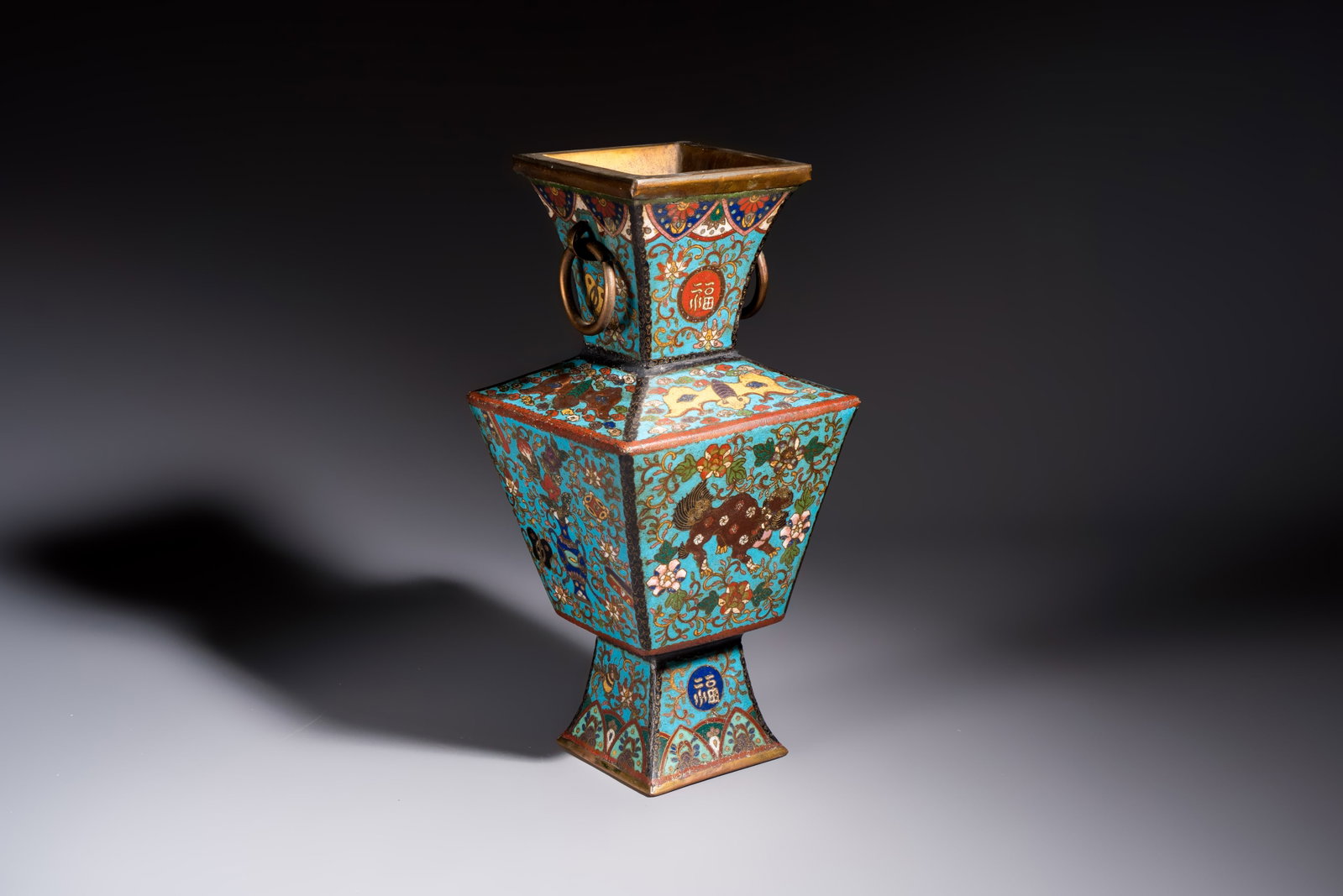 A Chinese cloisonné square 'Buddhist Lions and Antiquities' vase, Fu mark, 19th C.: A Chinese cloisonné square 'Buddhist Lions and Antiquities' vase, Fu mark, 19th C. H.: 33,9 cm Weight: 2,4 kilograms