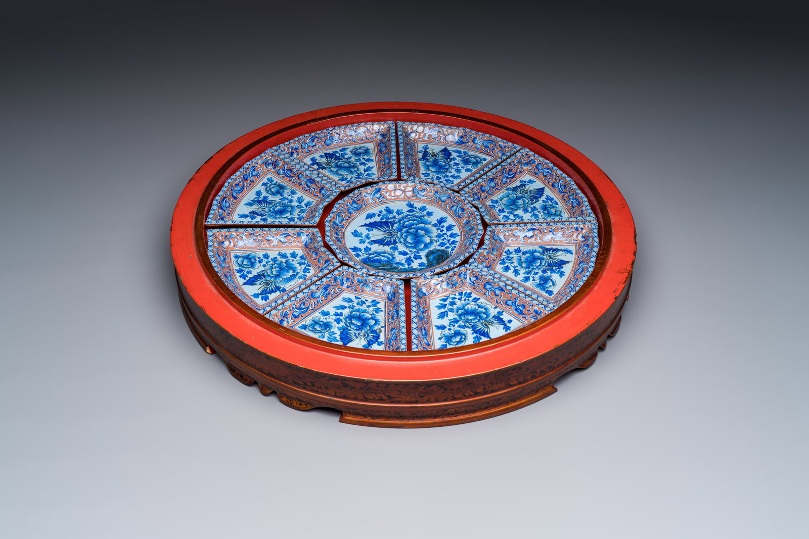 A Chinese enamelled Yixing stoneware nine-piece 'peonies' sweetmeat set on a Southeast Asian lacquer: A Chinese enamelled Yixing stoneware nine-piece 'peonies' sweetmeat set on a Southeast Asian lacquer tray, 19th C. Dia.: 49,5 cm - H.: 7 cm (the tray) Dia.: 17,2 cm (the centre piece) Dim.: 15,7 x 12 