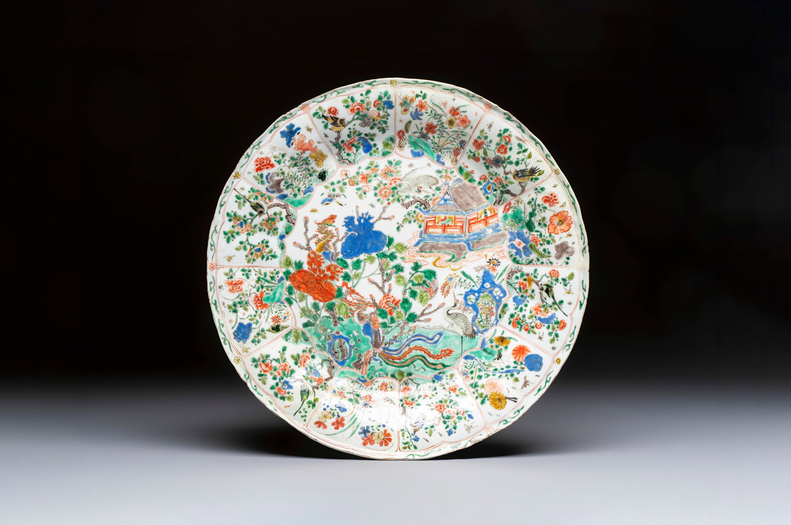 A large Chinese famille verte 'Pavilion with Birds among Flowering Branches' dish, Kangxi (1 of 2)