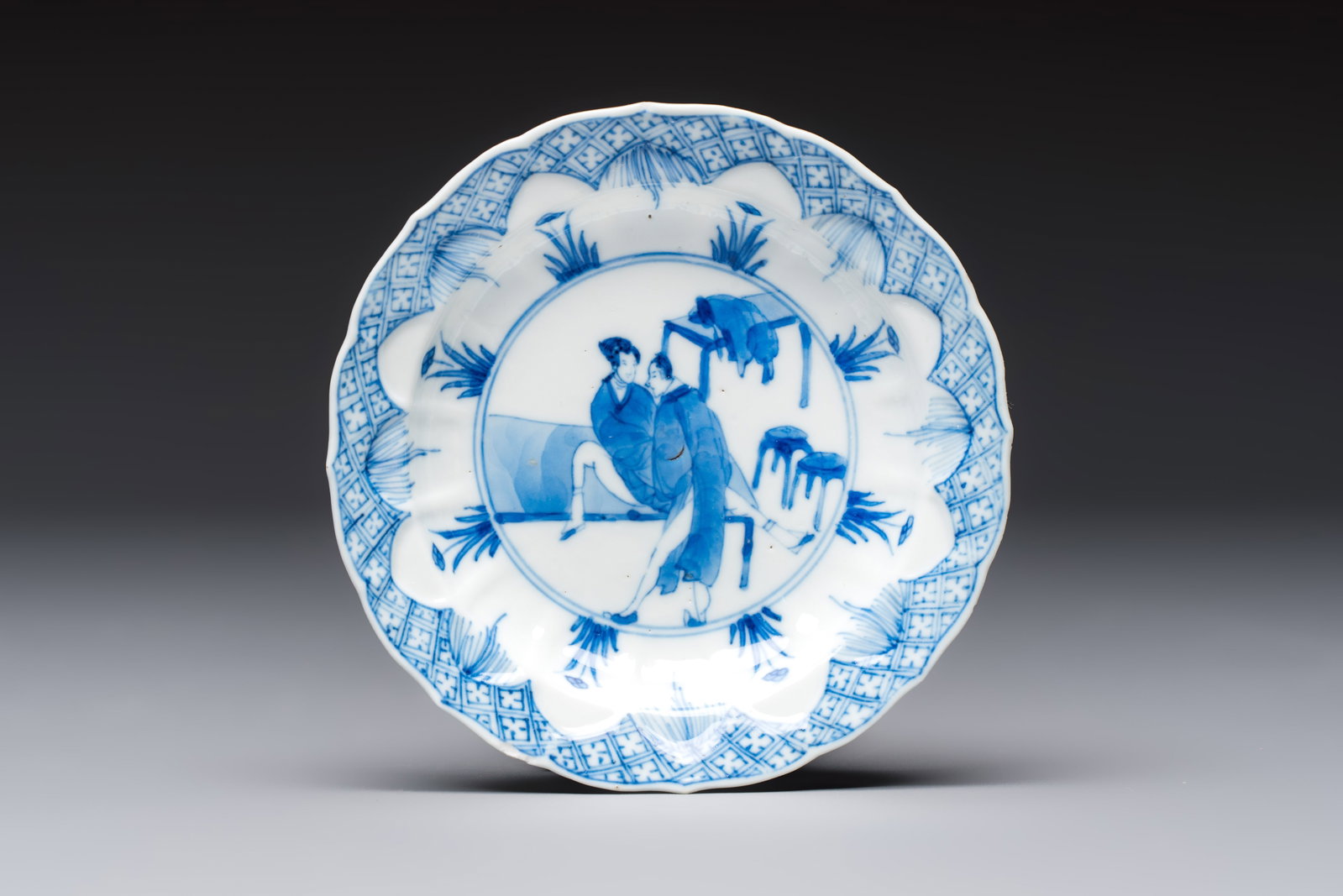 A Chinese blue and white 'Erotic Subject' saucer, Chenghua mark, Kangxi (1 of 2)