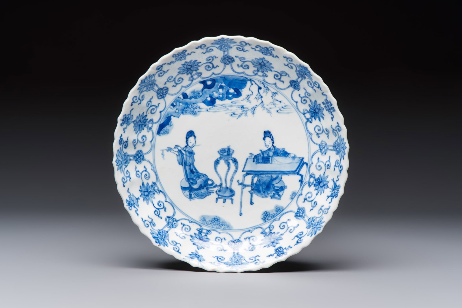 A Chinese blue and white 'Elegant Ladies Making Music' plate, Chenghua mark, Kangxi (1 of 2)