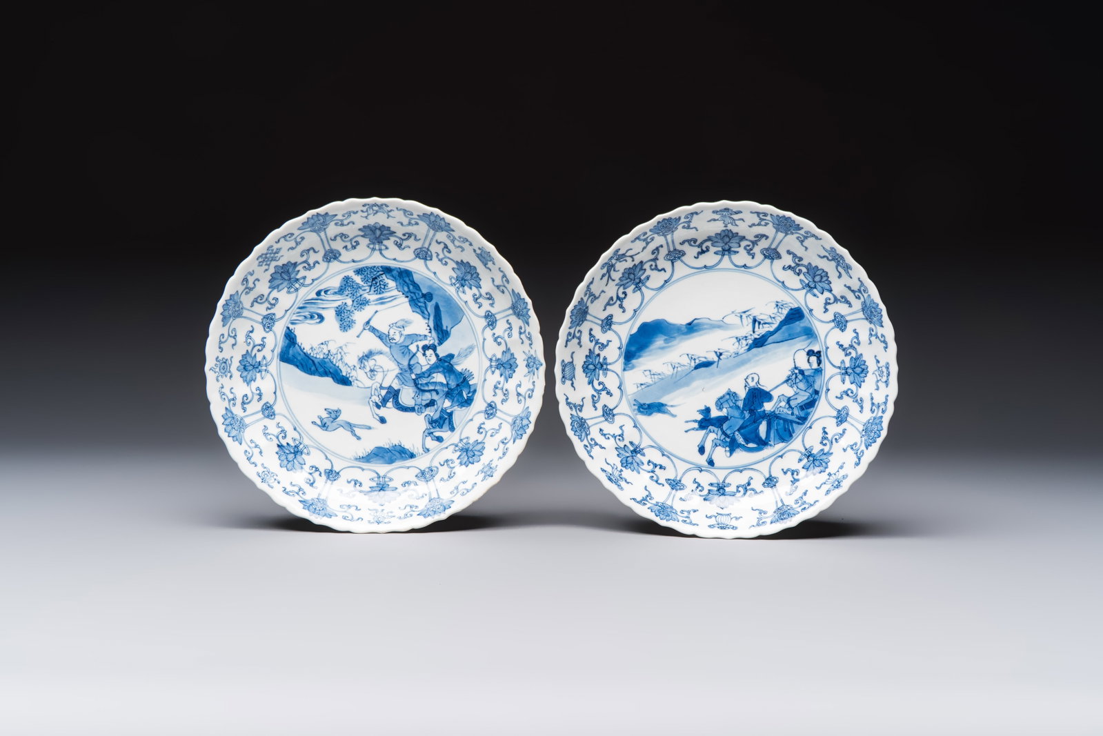 A pair of Chinese blue and white 'Hunting' plates, Chenghua marks, Kangxi (1 of 2)
