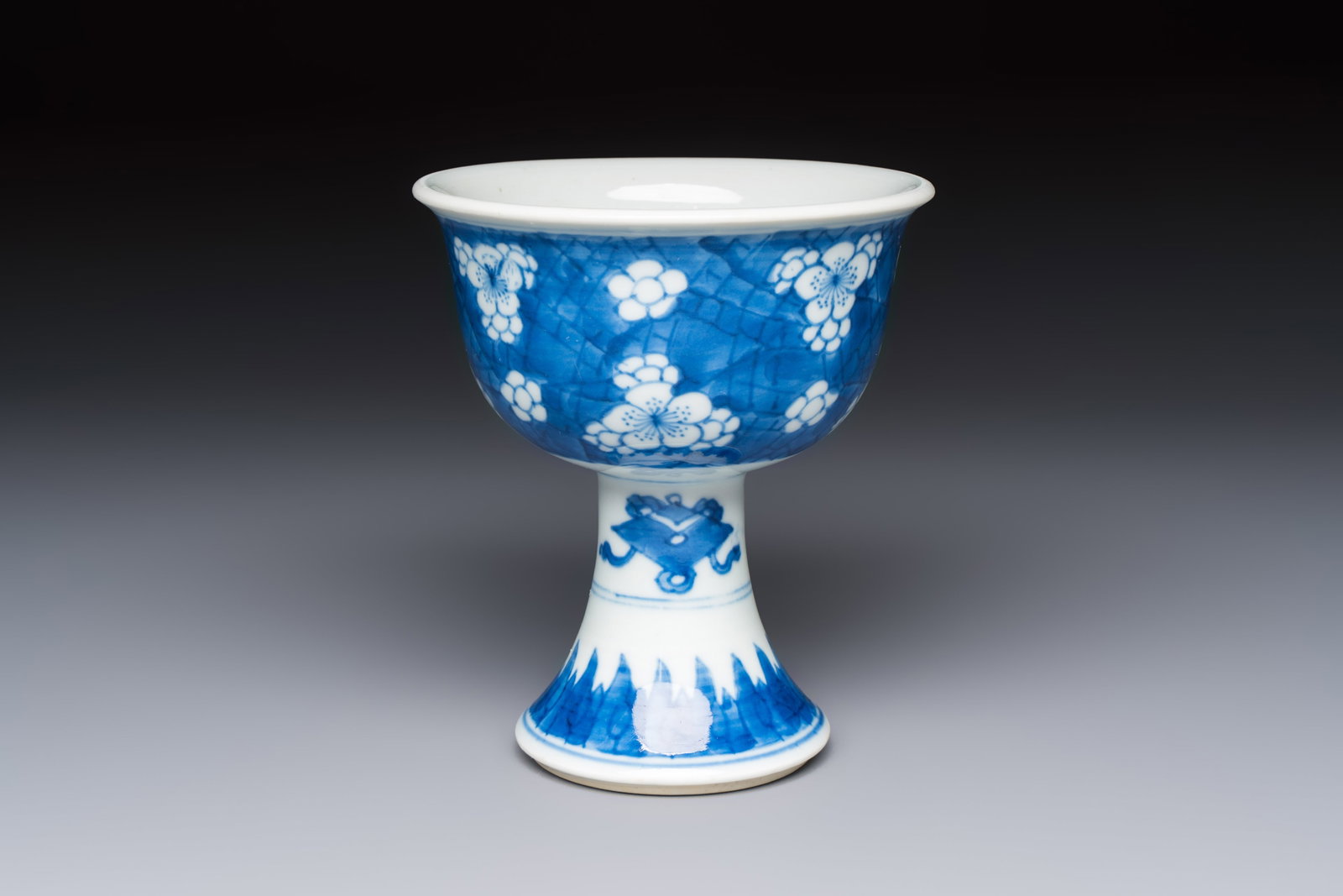 A Chinese blue and white 'Prunus on Cracked Ice' stem bowl, Kangxi: A Chinese blue and white 'Prunus on Cracked Ice' stem bowl, Kangxi Dia.: 11 cm - H.: 12,3 cm Provenance: - With a label of Hamadi Oriental Art, Hattem, the Netherlands.