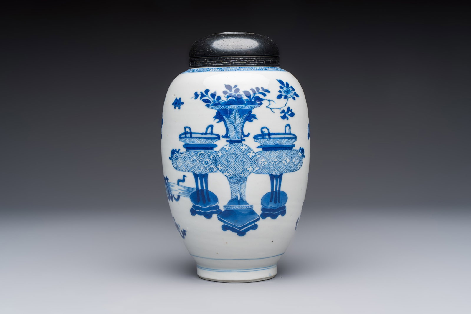 A Chinese blue and white ovoid 'Antiquities' jar with a wooden cover, Kangxi (1 of 9)