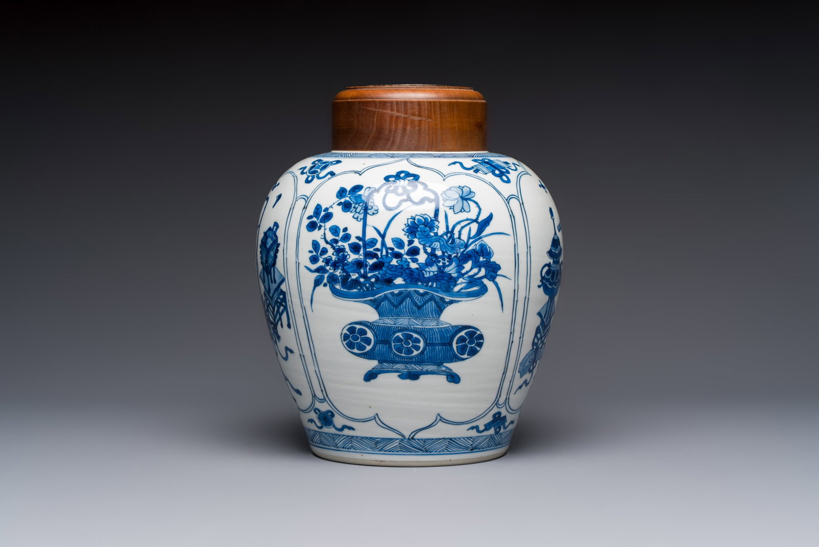 A Chinese blue and white 'Antiquities and Flower Baskets' vase with a wooden cover, Kangxi (1 of 9)