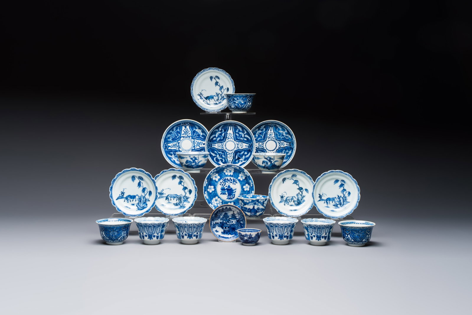 11 Chinese blue and white cups and 10 saucers, Kangxi and jade marks, 18/19th C.: 11 Chinese blue and white cups and 10 saucers, Kangxi and jade marks, 18/19th C. Dia.: 13,1 cm (the largest saucer) Dia.: 8,7 cm - H.: 5,2 cm (the largest cup) Dia.: 8,8 cm (the smallest saucer) Dia.:
