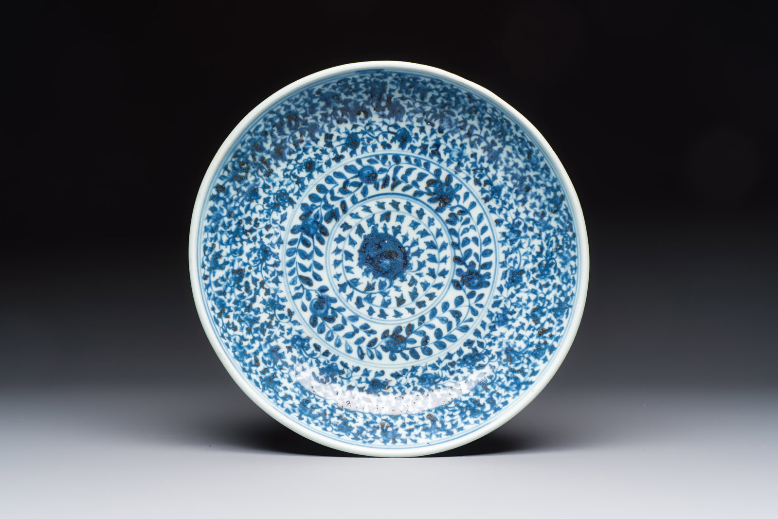 A Chinese blue and white dish with floral design, Hongzhi/Zhengde: A Chinese blue and white dish with floral design, Hongzhi/Zhengde Dia.: 31,8 cm Provenance: - The base witha label of the National Museum of The Philippines Manila, registration number: XX-494 79-532.