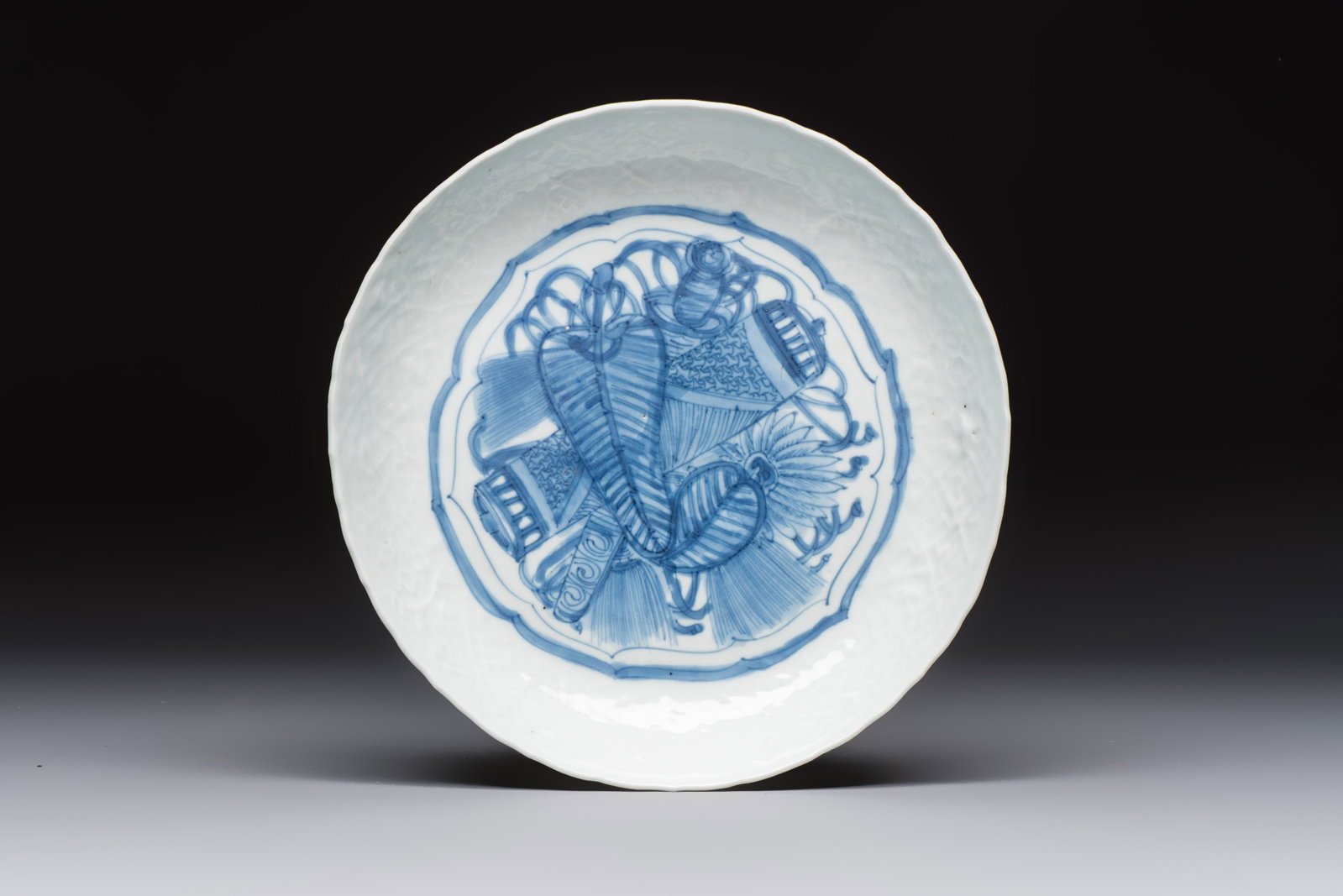 A Chinese blue and white plate with a relief-moulded rim, Wanli (1 of 2)