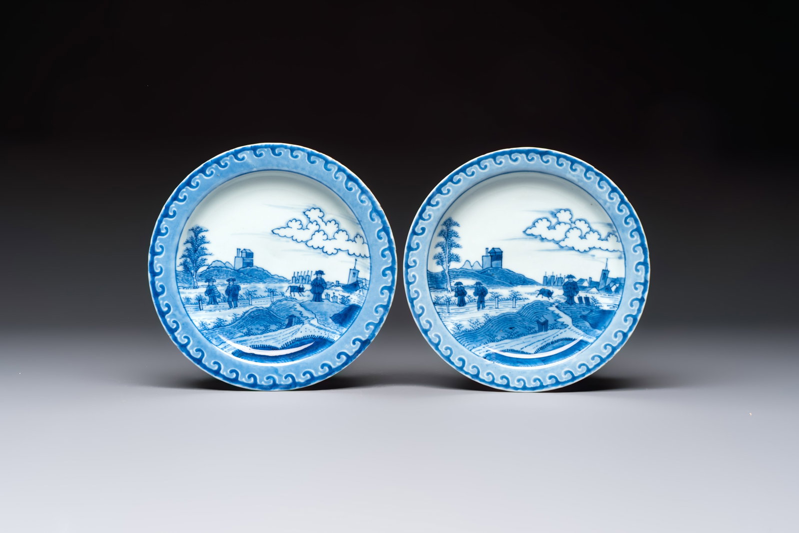 A pair of Chinese blue and white 'Scheveningen' or 'Nabeshima' plates, Kangxi/Yongzheng: A pair of Chinese blue and white 'Scheveningen' or 'Nabeshima' plates, Kangxi/Yongzheng Dia.: 19,8 cm Decorated in underglaze blue with a Dutch coastal landscape traditionally known as the 'Schevening