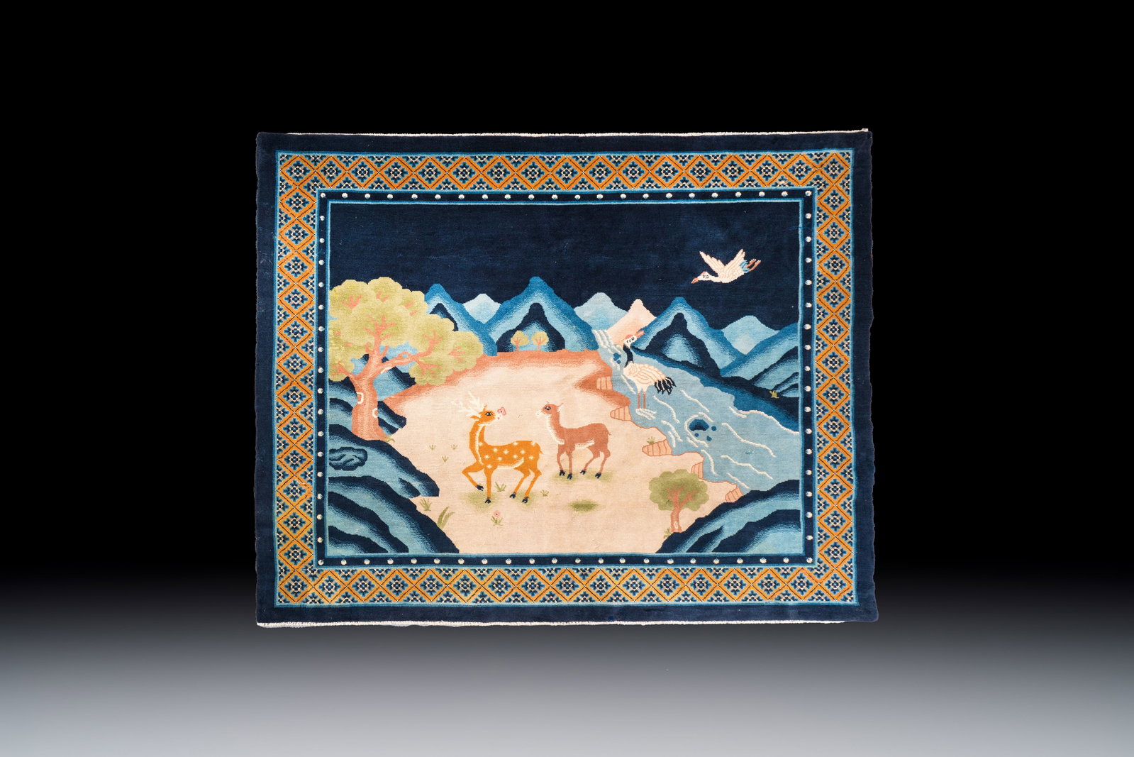 A Chinese woollen 'Cranes and Deer' carpet, 20th C. (1 of 2)