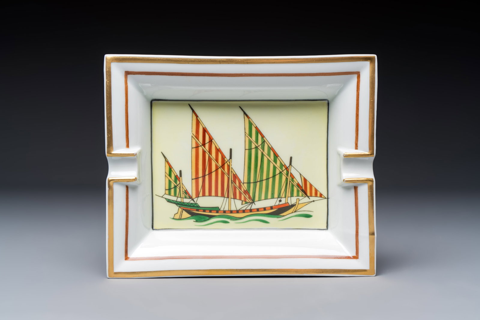 A gilt and polychrome-decorated porcelain 'Yacht' ashtray, Hermès, 20th C. (1 of 4)