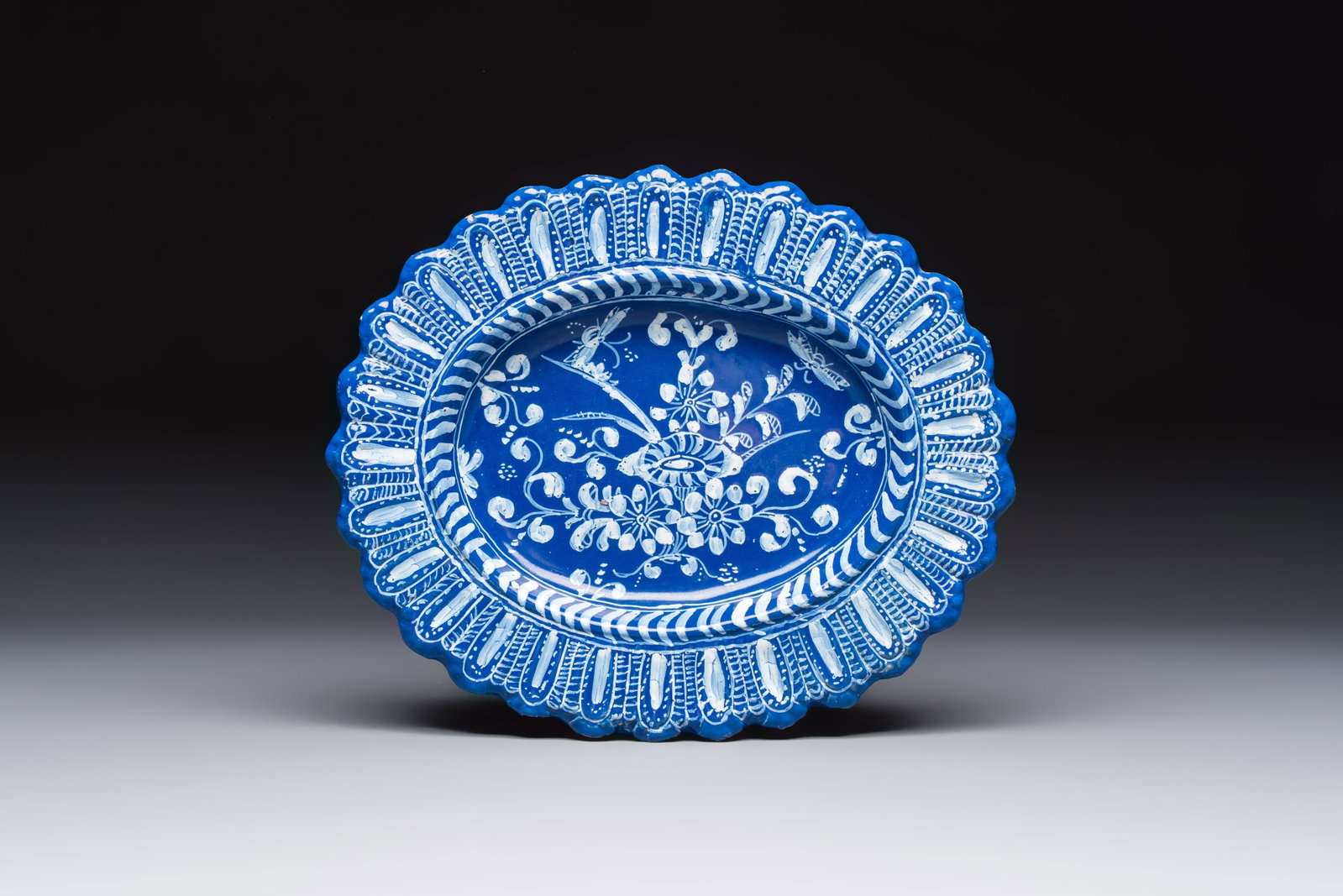 An oval French Persian-blue-ground white-decorated faience dish with butterflies and foliage,: An oval French Persian-blue-ground white-decorated faience dish with butterflies and foliage, Nevers, 17th C. Dim.: 29,8 x 24,8 cm
