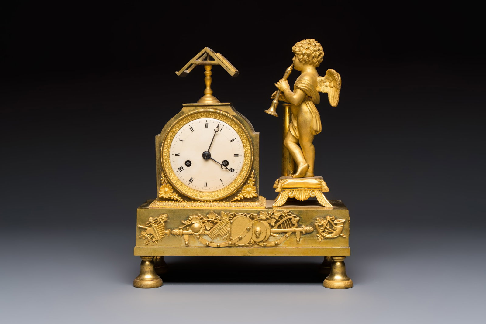 A French fire-gilt mantel clock with a music making cherub, early 19th C. (1 of 7)