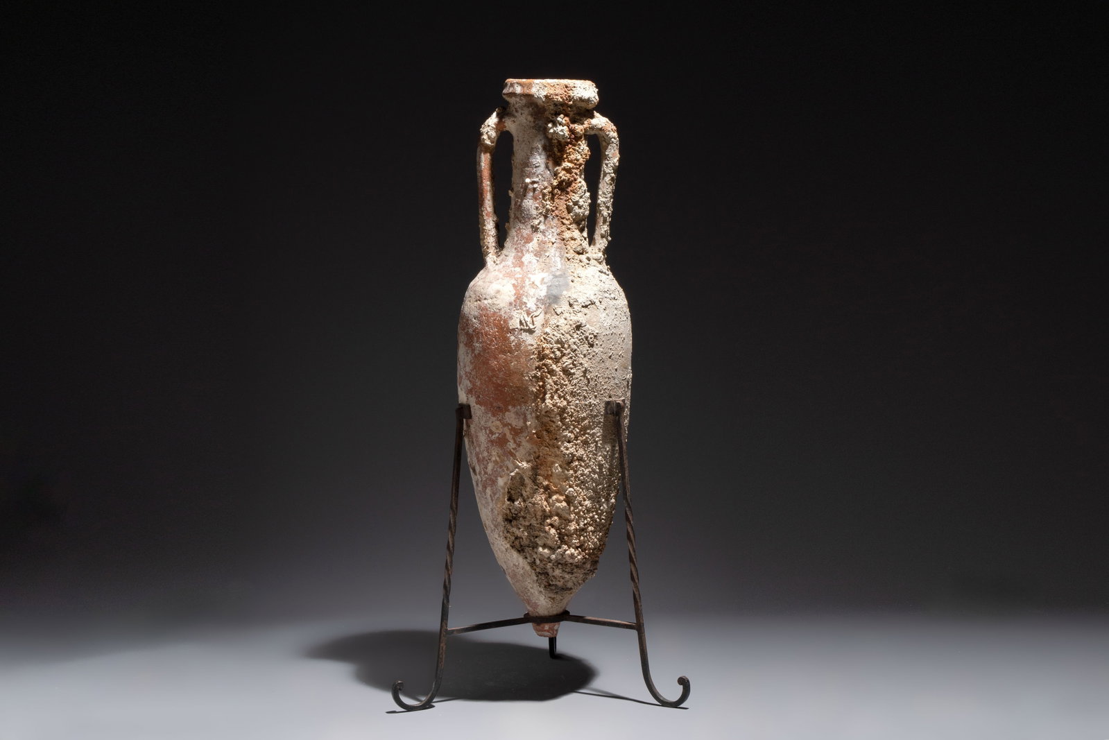 A Roman pottery fish oil or wine transport amphora with marine encrustation, South of Spain, 1st C.: A Roman pottery fish oil or wine transport amphora with marine encrustation, South of Spain, 1st C. B.C./1st C. H.: 106,5 cm (incl. stand) H.: 98,5 cm (excl. stand) Can be classified in the Dressel ty