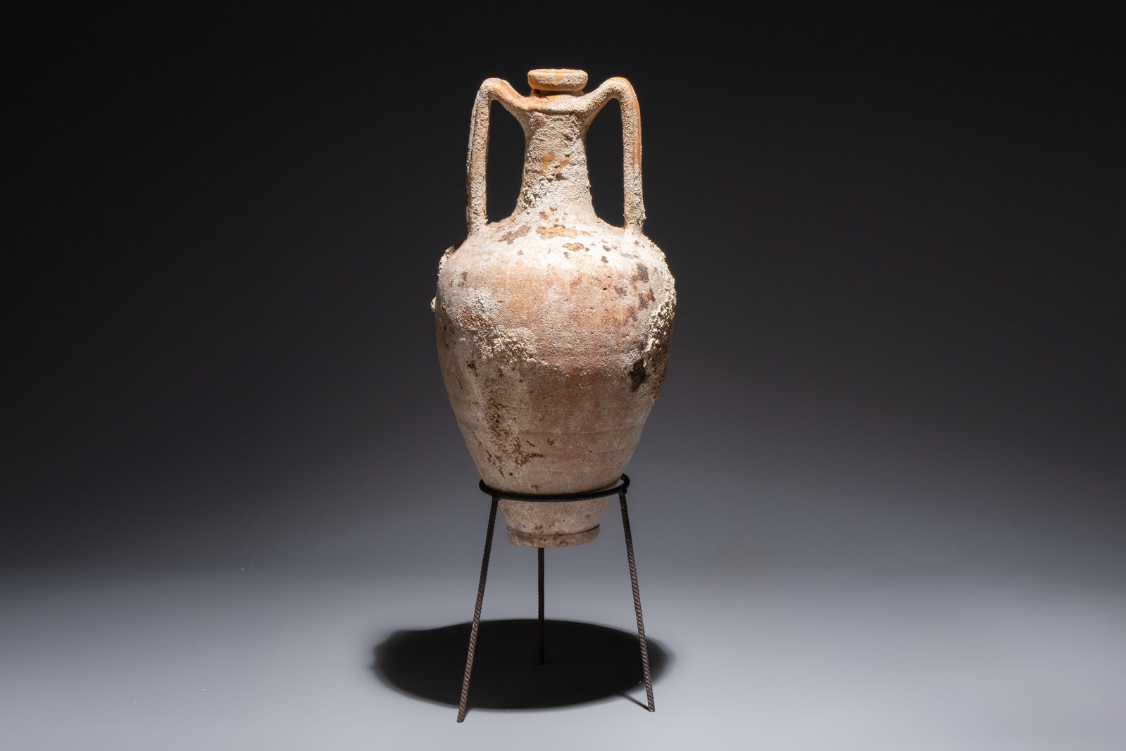 A Roman pottery wine transport amphora with marine encrustation, Northern Adriatic region, 1st C.: A Roman pottery wine transport amphora with marine encrustation, Northern Adriatic region, 1st C. B.C./3rd C. H.: 85 cm (incl. stand) H.: 64,5 cm (excl. stand) Can be classified in the Dressel typolog