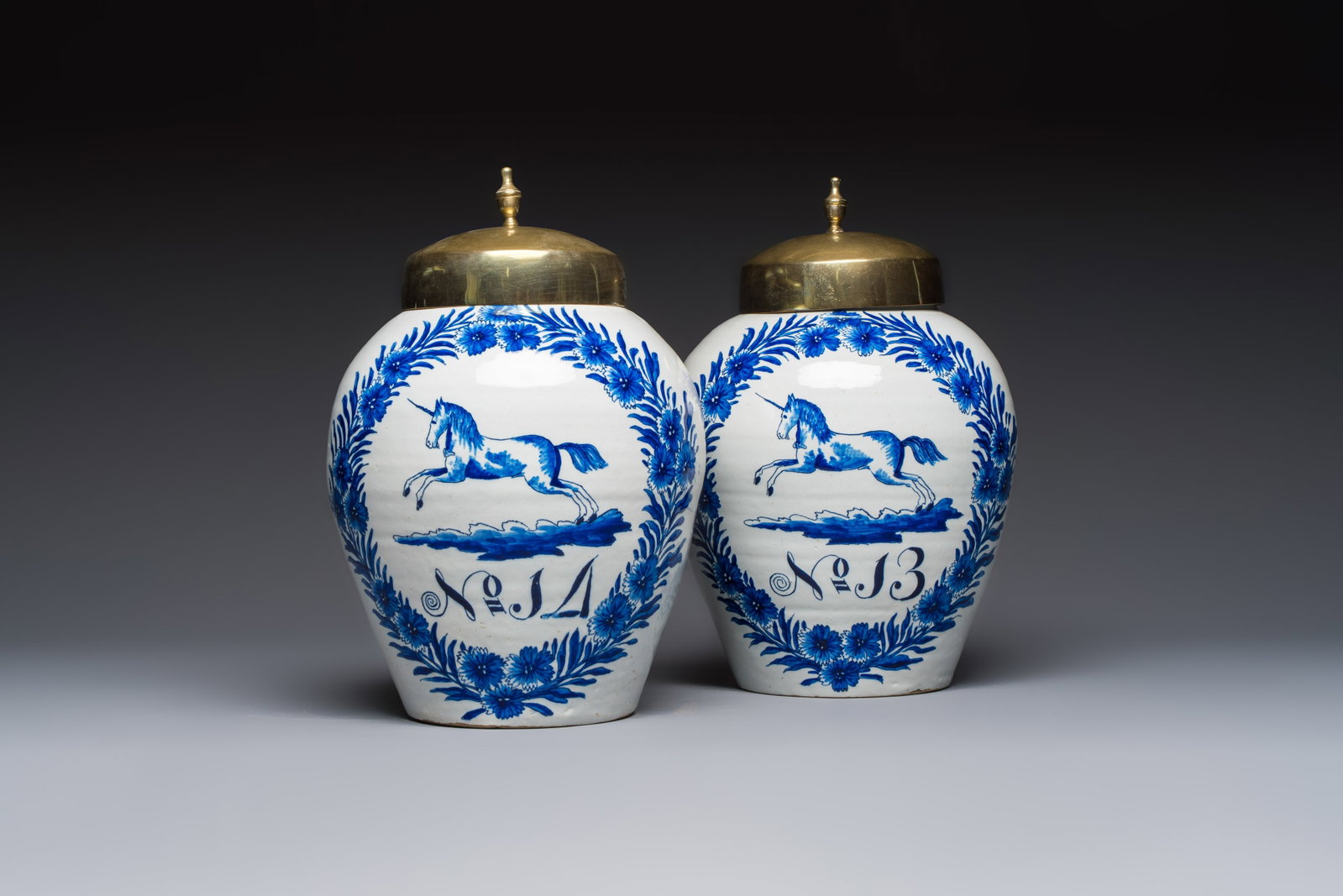A pair of blue and white Dutch Delft 'Leaping Unicorn' tobacco jars, 18th C.: A pair of blue and white Dutch Delft 'Leaping Unicorn' tobacco jars, 18th C. H.: 32,4 cm (incl. cover) H.: 26 cm cm (excl. cover) Both marked on the base with a figurative claw for the 'De Klaauw' wor