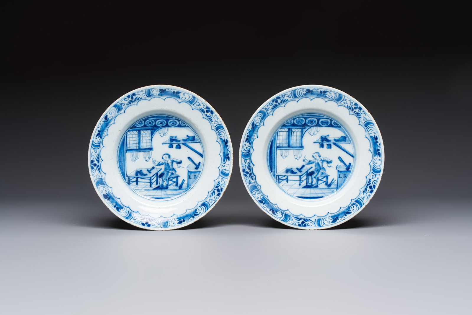 A pair of rare blue and white Dutch Delft 'Shoemaker' plates, 18th C. (1 of 2)