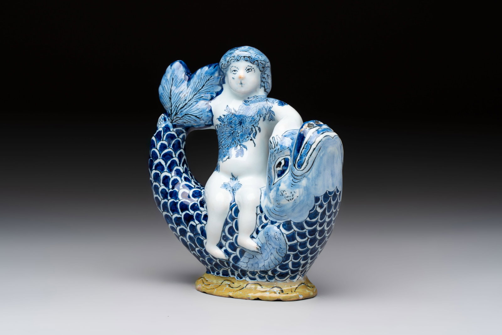 A blue and white Dutch Delft ewer in the shape of a putto on a dolphin on a wavy green ground, 18th (1 of 8)