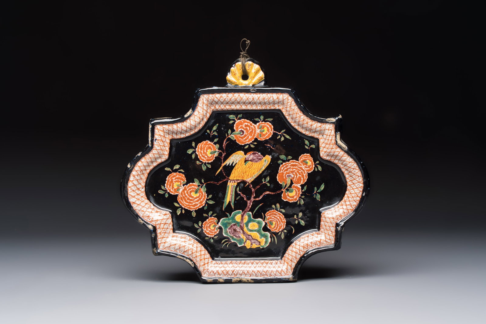 An exceedingly rare polychrome black-ground Dutch Delft plaque with a parrot, 18th C. (1 of 2)