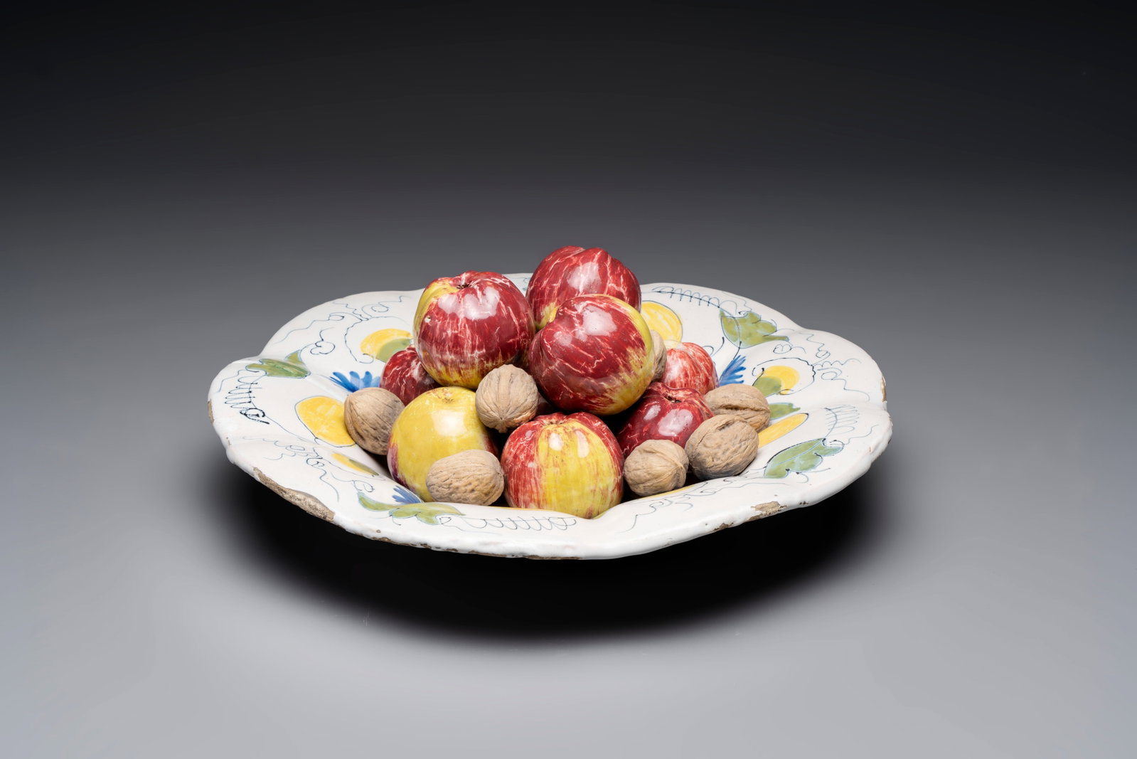A rare polychrome Dutch Delft trompe-l'oeil dish with apples and walnuts, 17th C. (1 of 3)