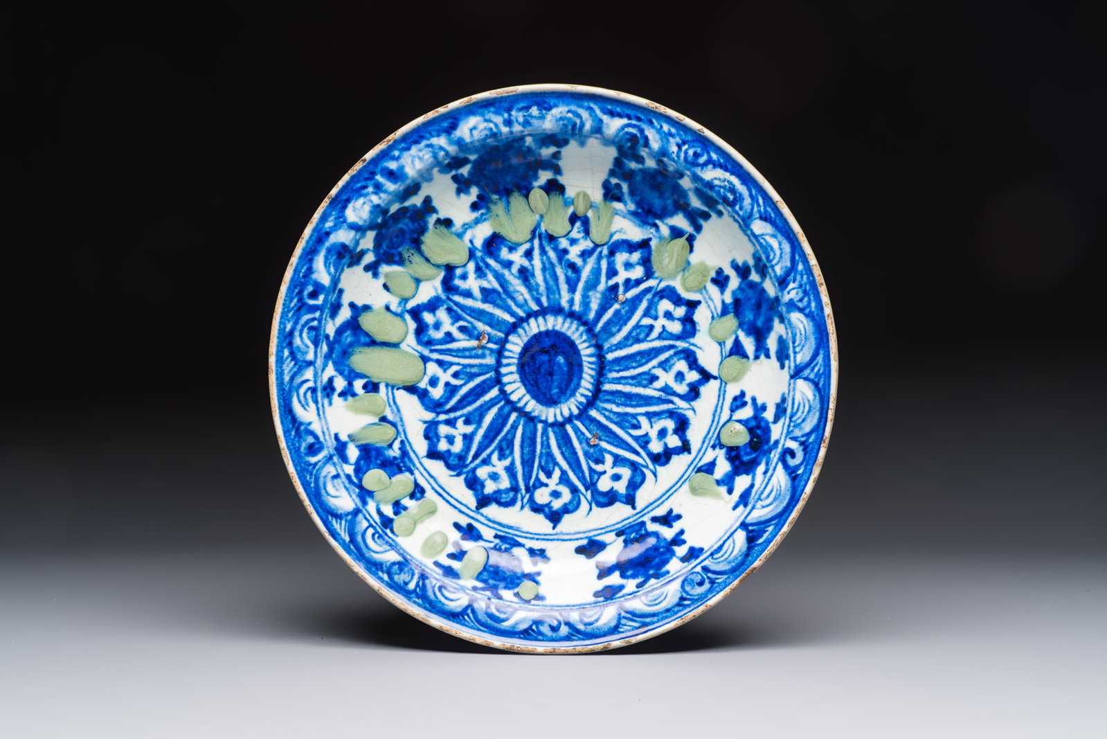 A Persian blue, white, and green glazed dish with stylised floral design, Safavid, 17/18th C. (1 of 2)
