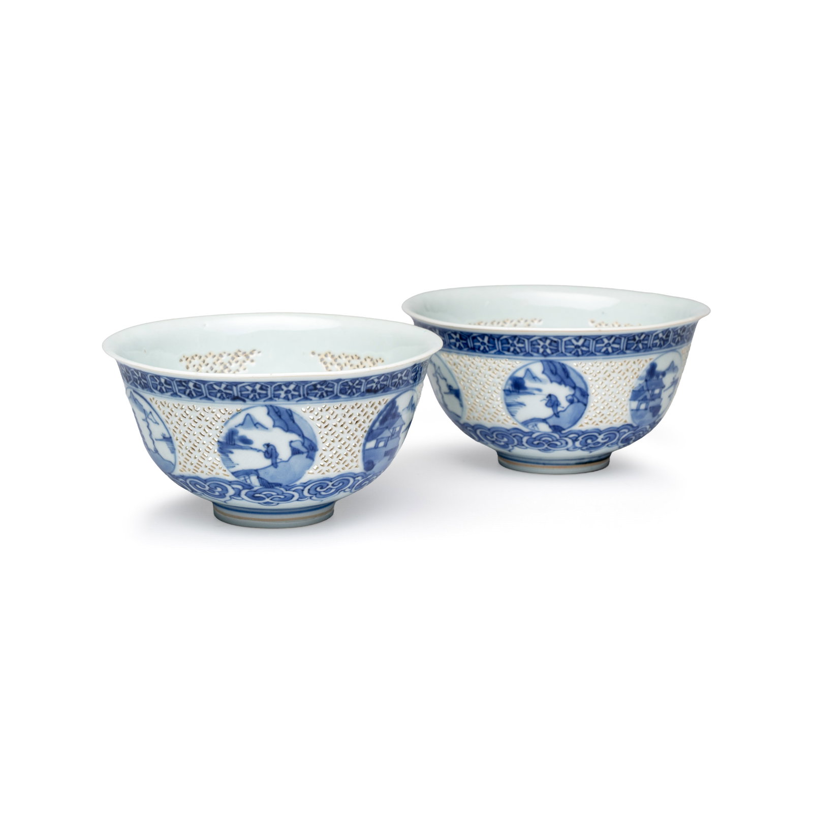 A pair of Chinese blue and white reticulated 'Linglong' bowls with landscape panels, Transitional: A pair of Chinese blue and white reticulated 'Linglong' bowls with landscape panels, Transitional period Dia.: 14,2 cm - H.: 7,4 cm Provenance: - A Dutch private collection. - Rob Michiels Auctions, B