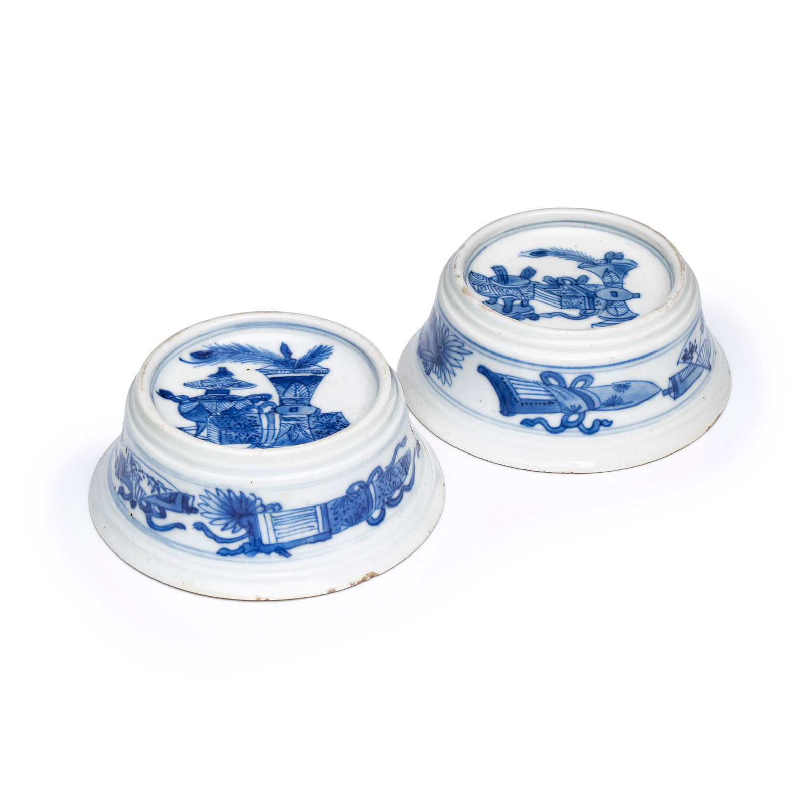 A pair of Chinese blue and white salt trenchers with antiquities design, Kangxi: A pair of Chinese blue and white salt trenchers with antiquities design, Kangxi Dia.: 8,6 cm - H.: 3,2 cm Provenance: - Rob Michiels Auctions, 28 April 2018, lot 301. (sold EUR 1.300,00) - The Mr. and