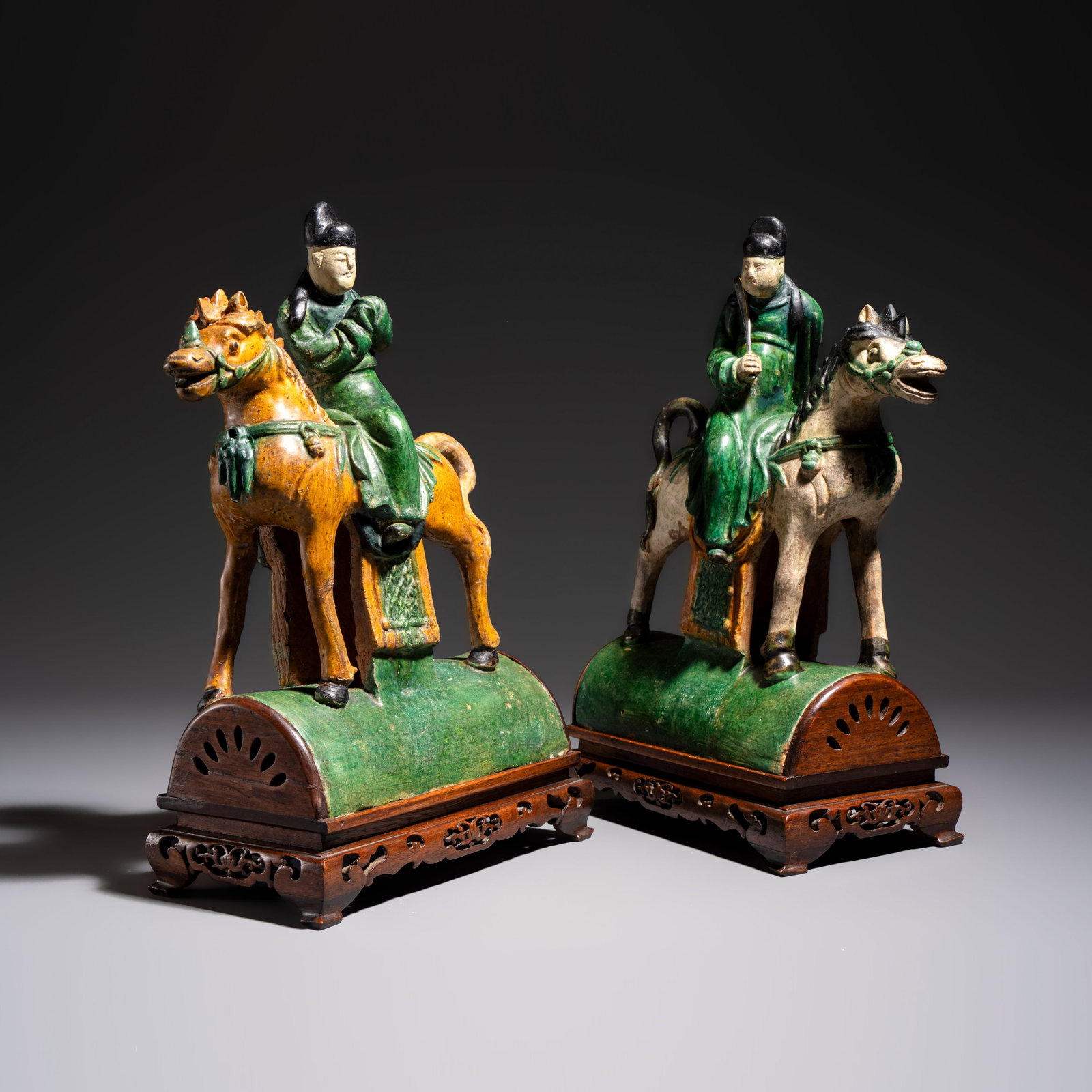 A pair of Chinese sancai-glazed stoneware 'Horseriders' roof tiles on later wooden stands, Ming (1 of 8)