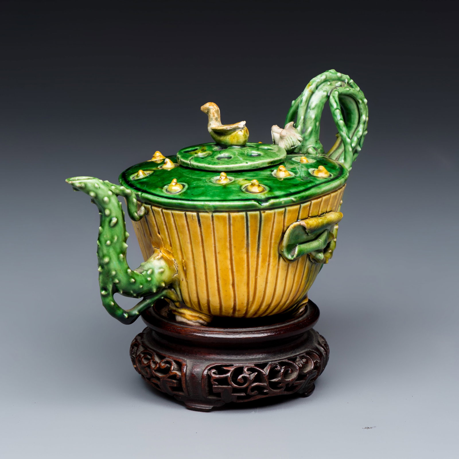 A Chinese famille verte sancai biscuit 'Lotus' teapot on a later wooden stand, Kangxi (1 of 9)