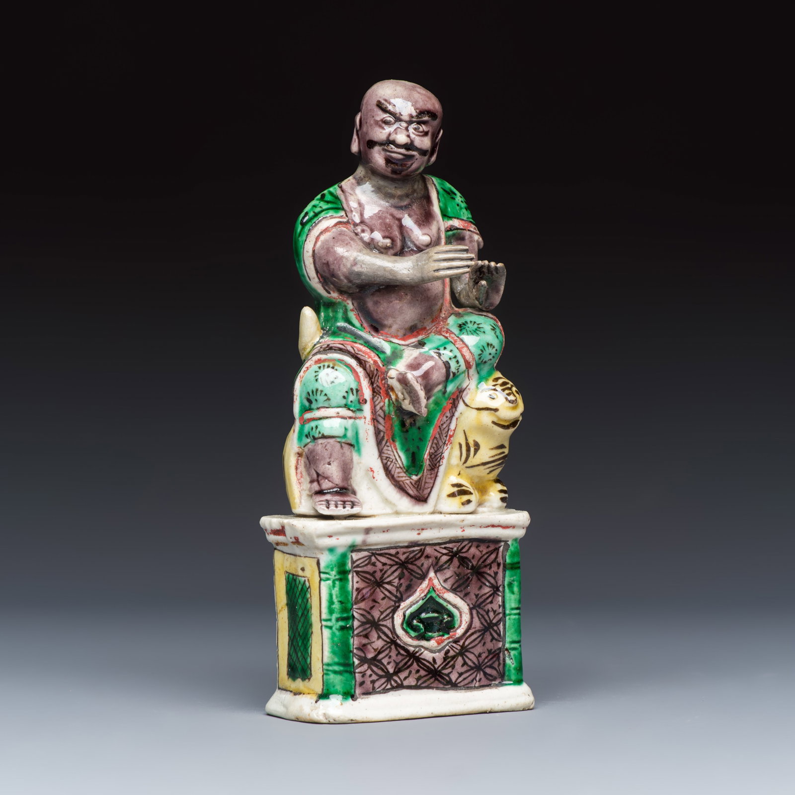 A Chinese famille verte sancai biscuit model of a seated Luohan on a tiger, Kangxi (1 of 7)