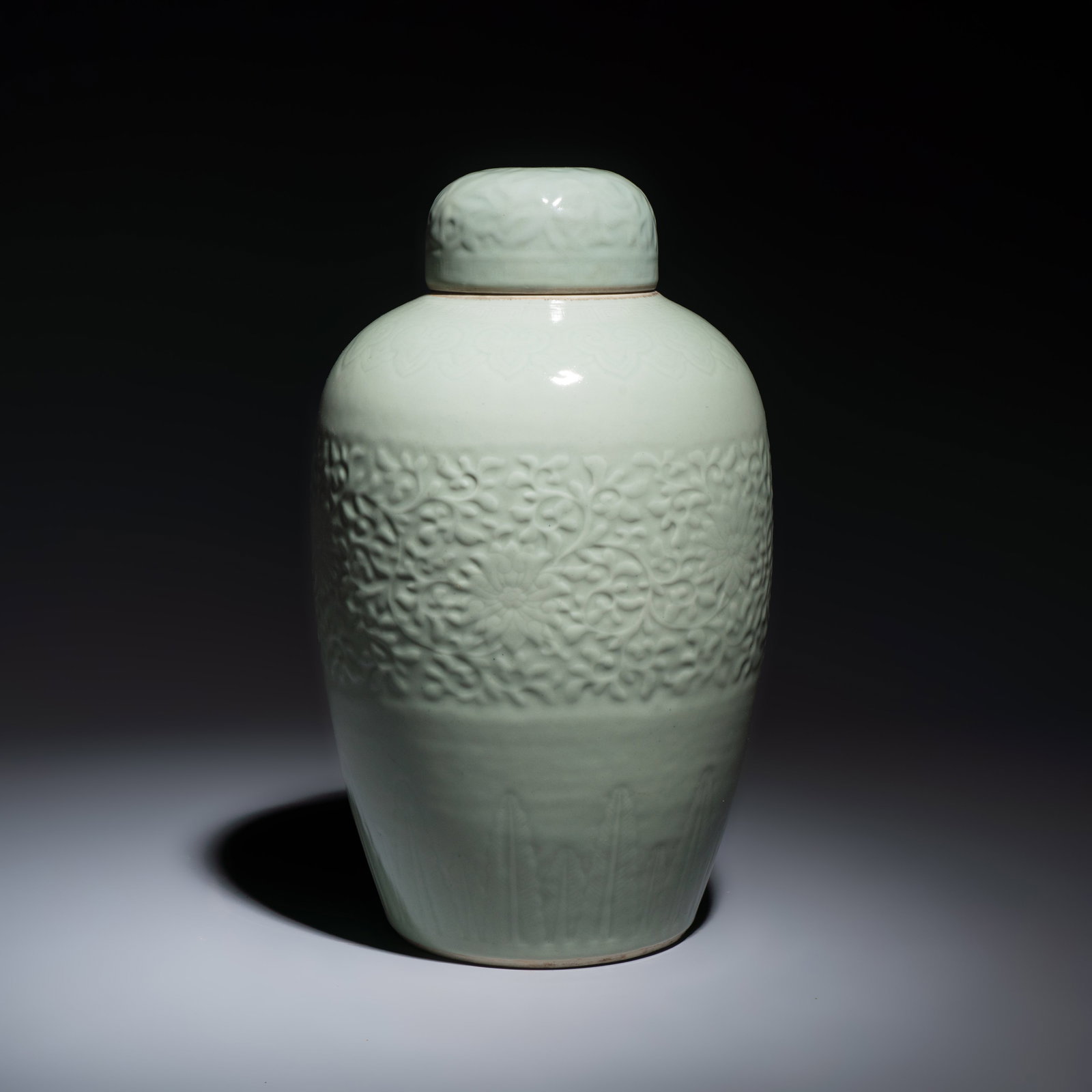 A Chinese celadon-glazed covered vase with floral relief design, Qianlong mark and of the period: A Chinese celadon-glazed covered vase with floral relief design, Qianlong mark and of the period H.: 39,2 cm | incl. cover