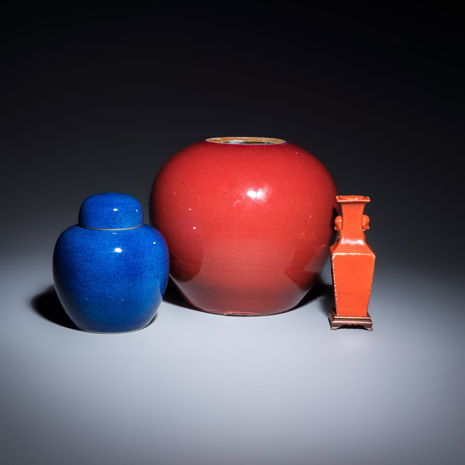 Three Chinese monochrome wares, one with a wooden stand, 19/20th C.: Three Chinese monochrome wares, one with a wooden stand, 19/20th C. H.: 20 cm | the largest H.: 13,5 cm | the smallest