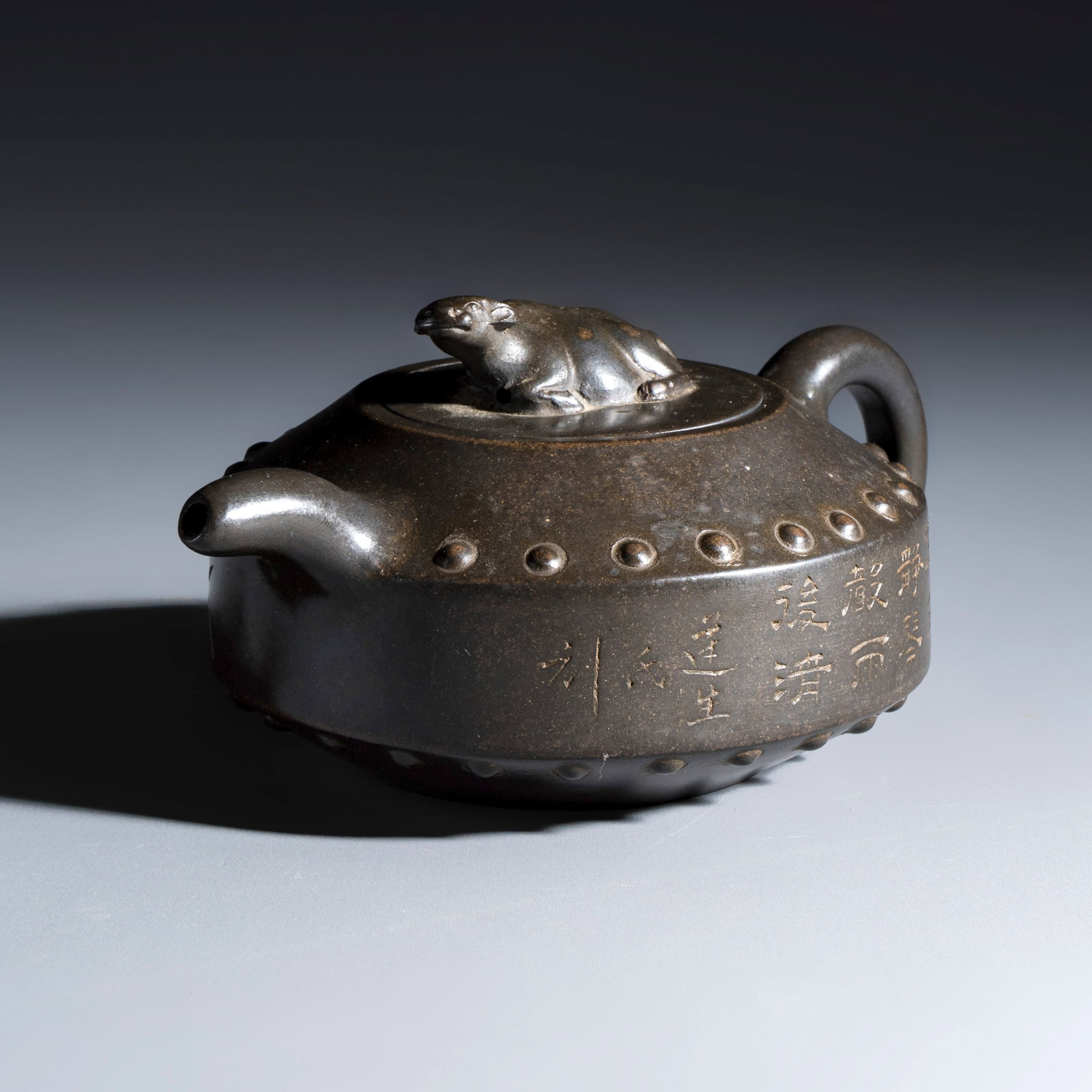 A Chinese inscribed Yixing stoneware teapot with a buffalo finial, Signed Shi Liansheng, 20th C.: A Chinese inscribed Yixing stoneware teapot with a buffalo finial, Signed Shi Liansheng, 20th C. L.: 18 cm - H.: 8,5 cm | incl. cover