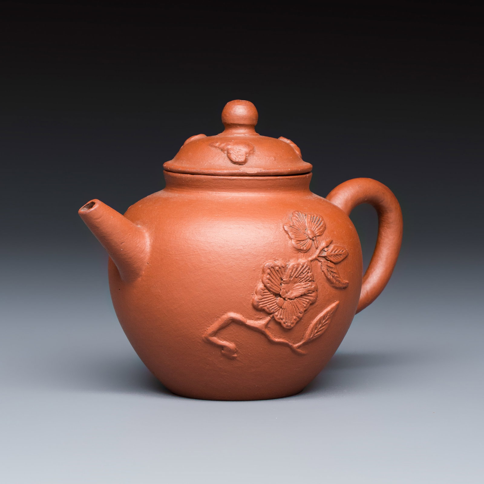A Chinese Yixing stoneware teapot and cover with floral relief design, Kangxi: A Chinese Yixing stoneware teapot and cover with floral relief design, Kangxi L.: 10,5 cm - H.: 8,3 cm | incl. cover